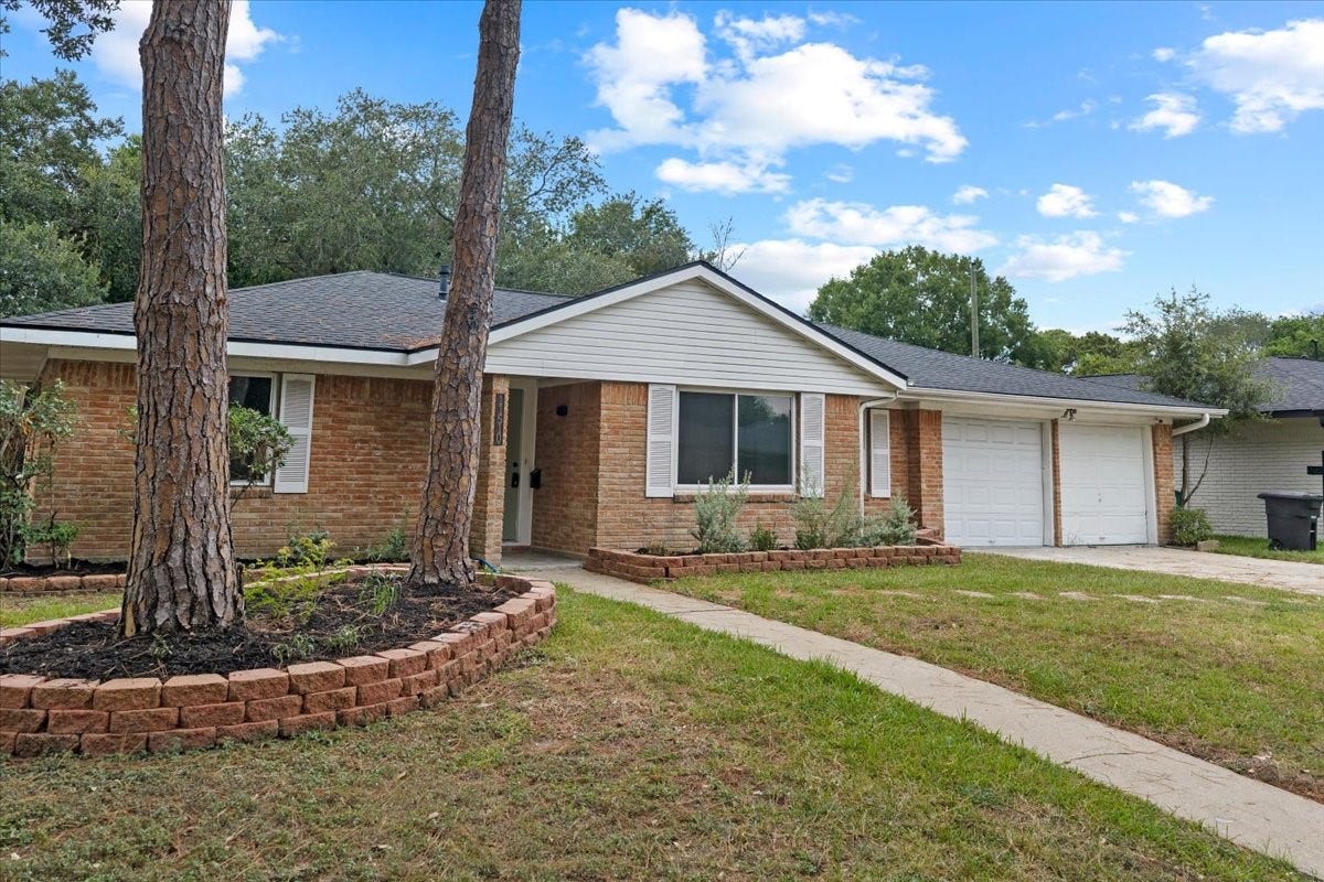11510 Mullins Drive, Houston, TX 77035 Charming brick home with a welcoming porch, two-car garage, and beautifully landscaped front yard.