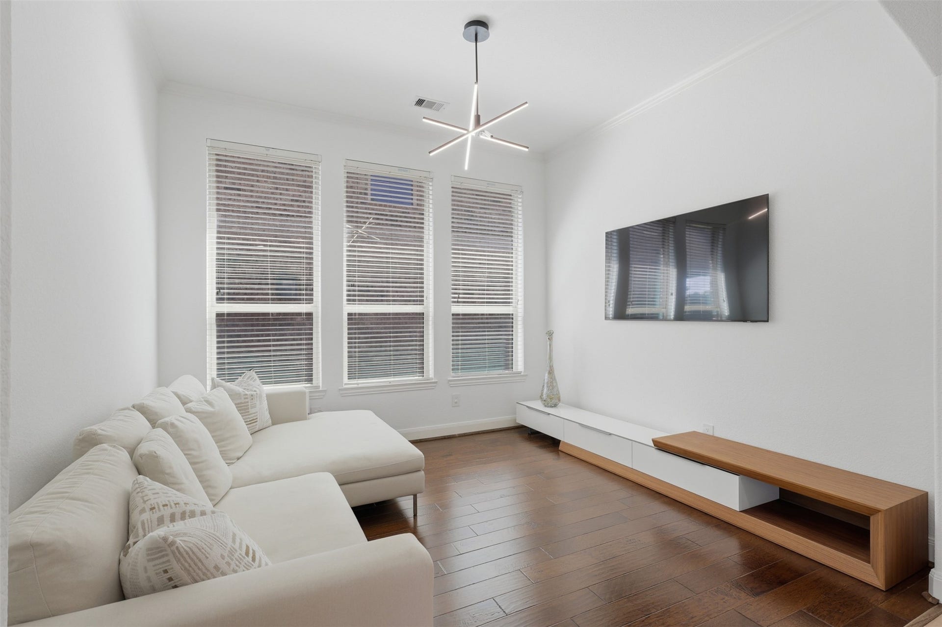 Additional view of the versatile formal dining room with a modern chandelier.