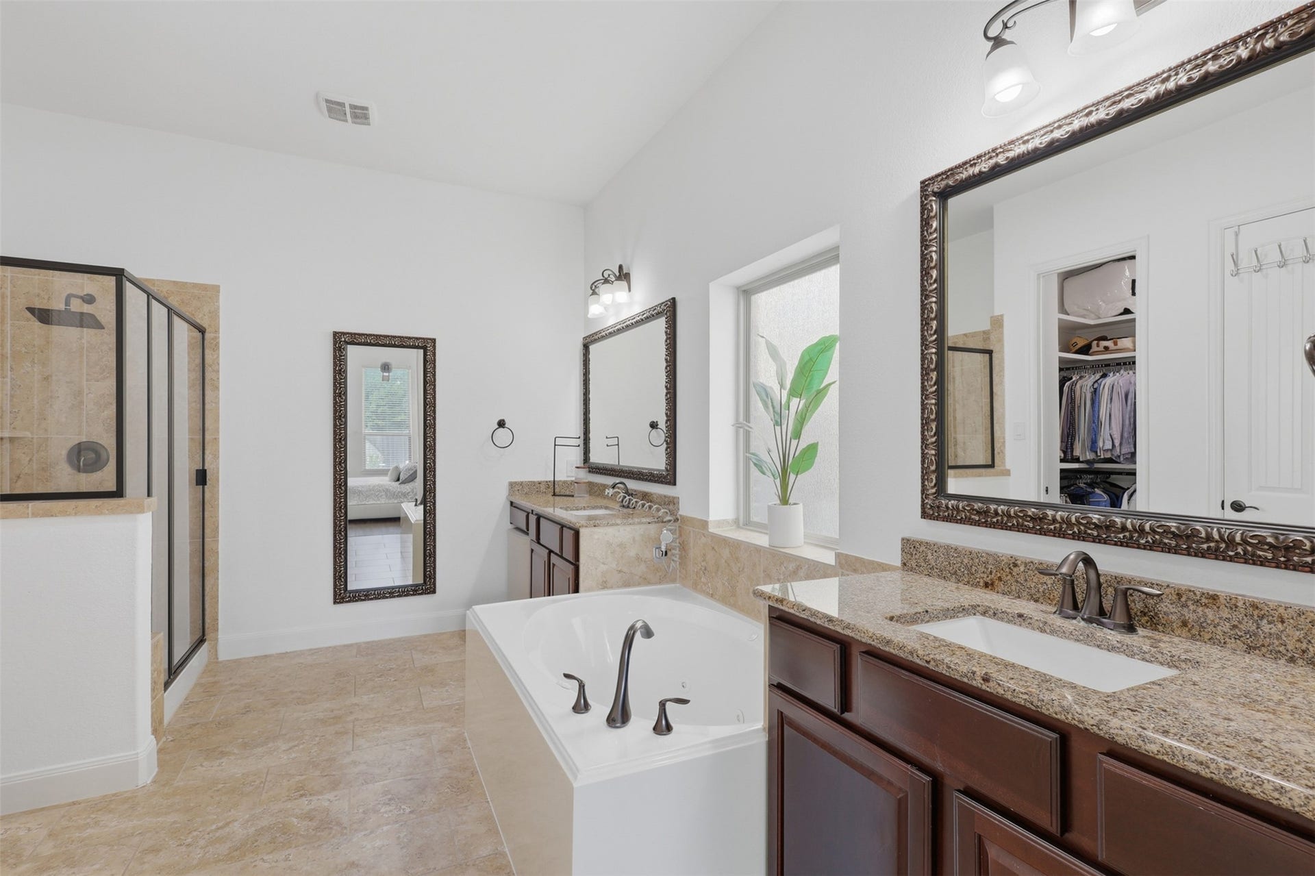 Primary bathroom features dual sinks, granite countertops, a jetted tub, and separate shower.