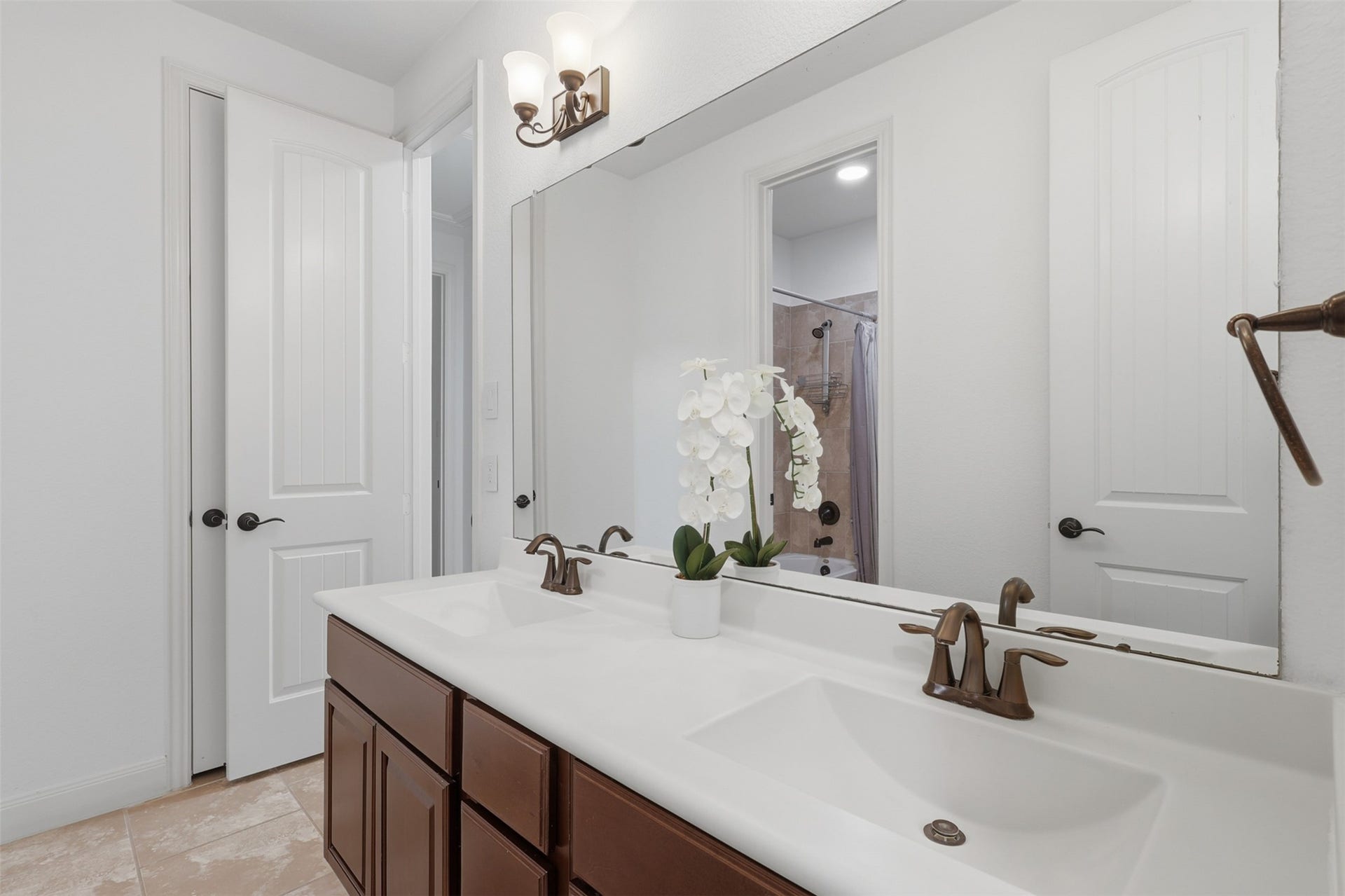 Secondary bathroom features a clean, neutral design and ample vanity storage.