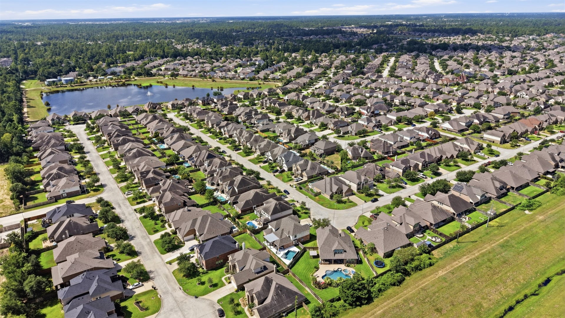 Aerial view showcasing the home, backyard, and surrounding neighborhood.
