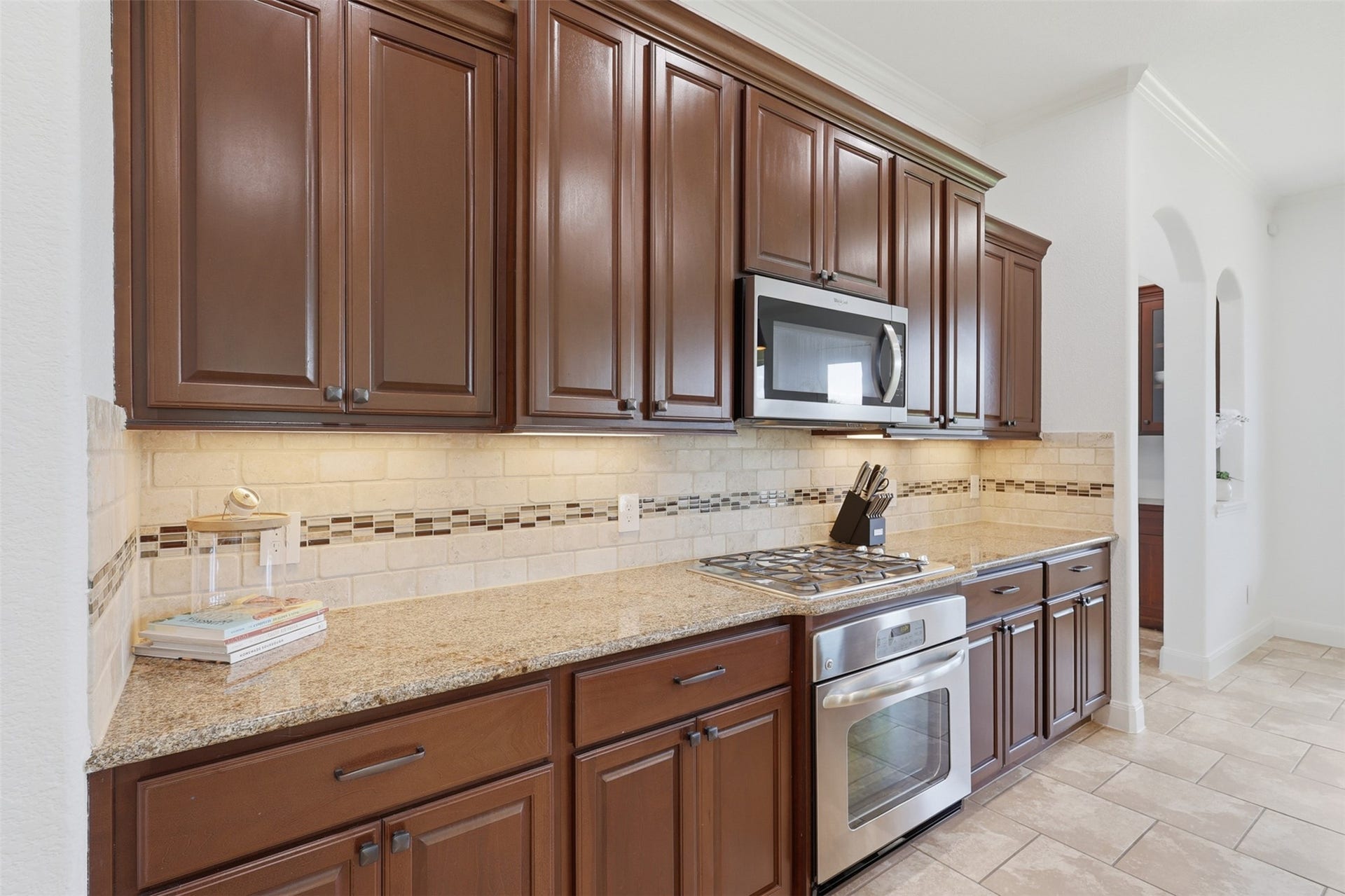 Rich wood cabinetry, granite countertops, and stainless steel appliances complete the kitchen.