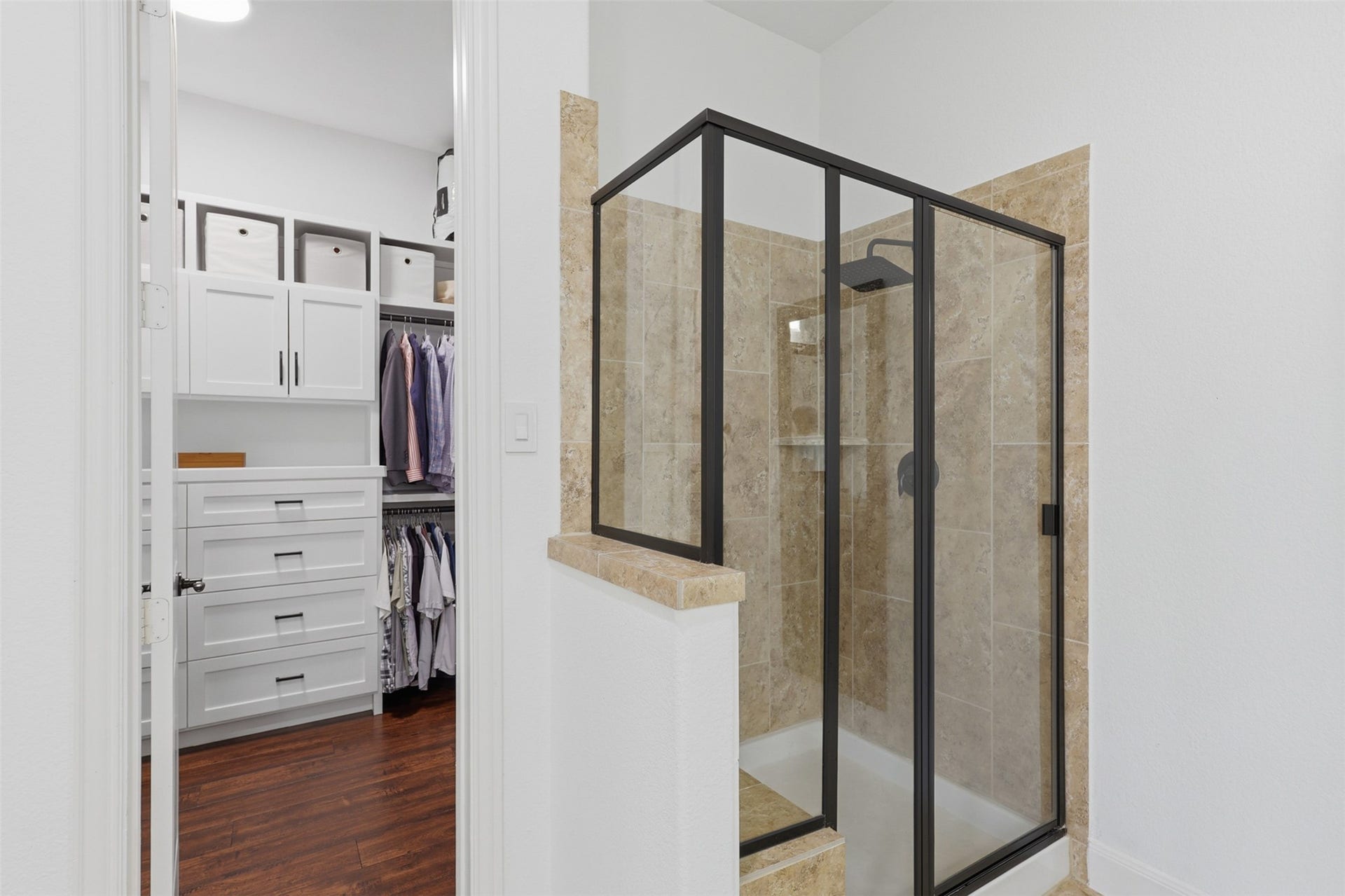 The walk-in shower features tile surround and a sitting area.