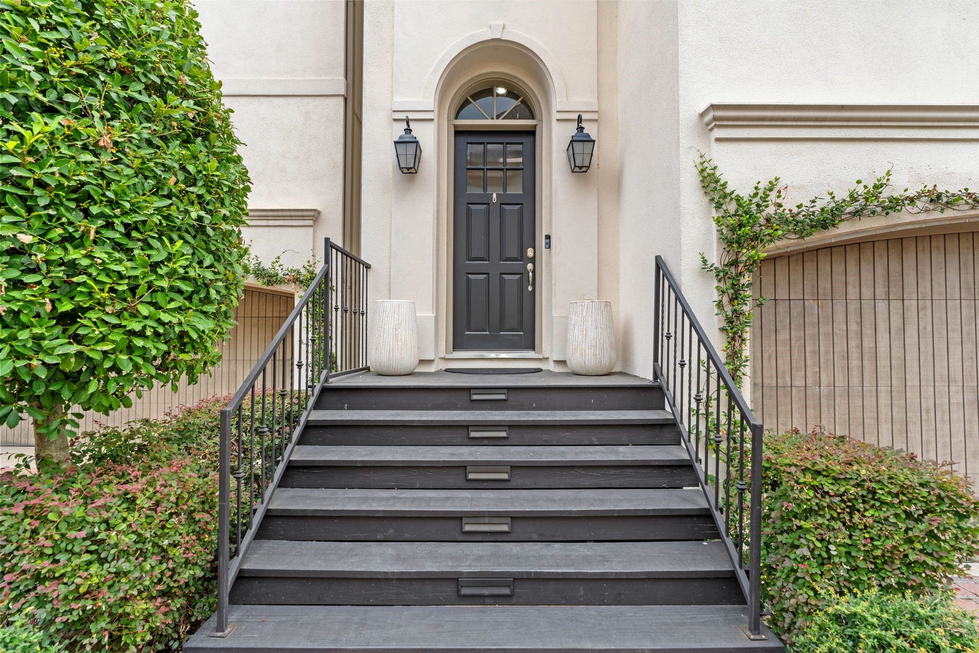 1337 W 24th Street, Houston, TX 77008 Welcome home to an inviting entrance framed by manicured greenery, an arched doorway and a decorative glass front door.