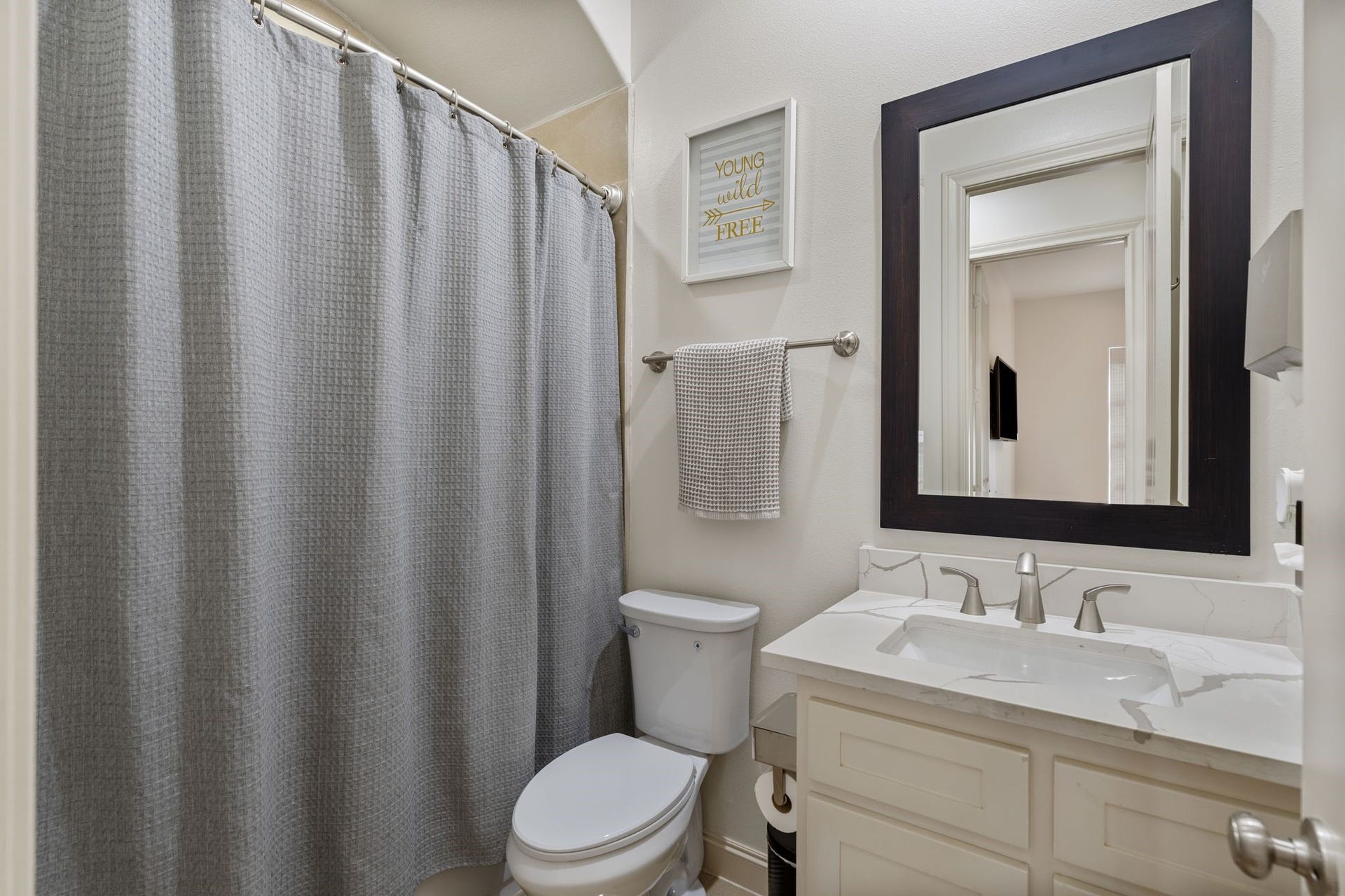 1337 W 24th Street, Houston, TX 77008 This bathroom features a vanity with storage, a framed mirror and a tub-and-shower combination.