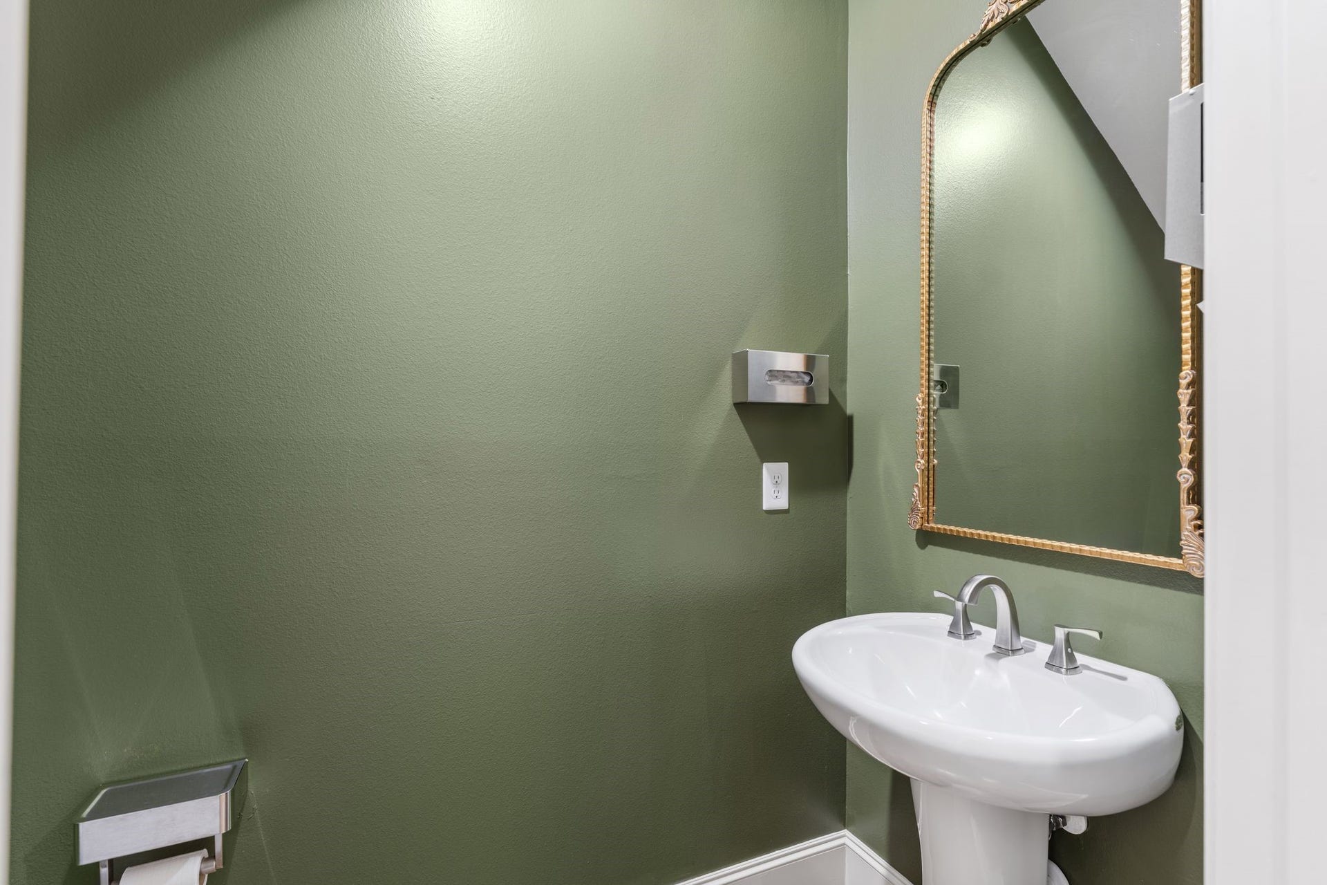 1337 W 24th Street, Houston, TX 77008 Rich green walls, an arched mirror and a pedestal sink give the powder room a distinctive touch.