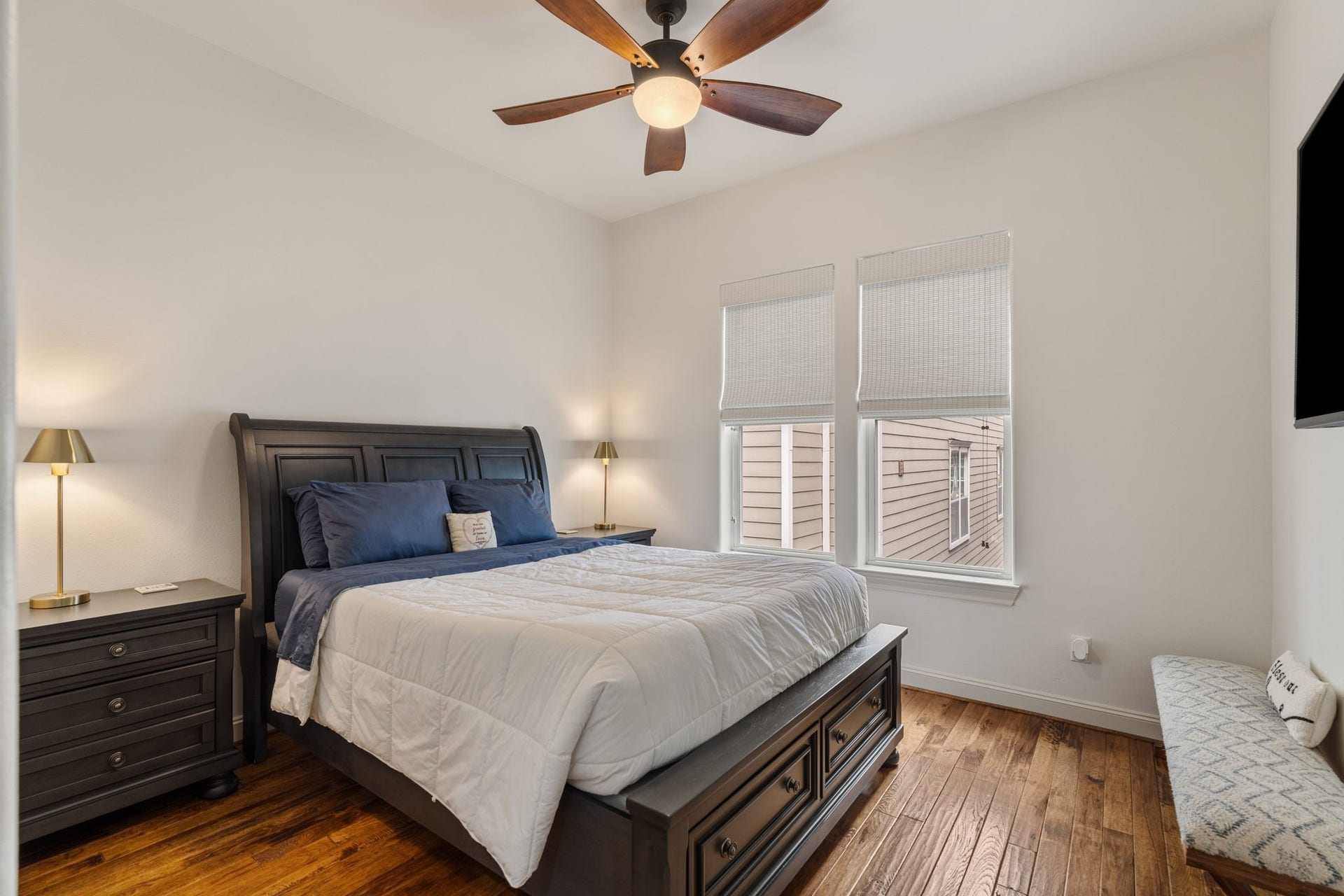 1337 W 24th Street, Houston, TX 77008 A secondary bedroom features a tray ceiling, ceiling fan and shuttered window, offering a welcoming space to relax.