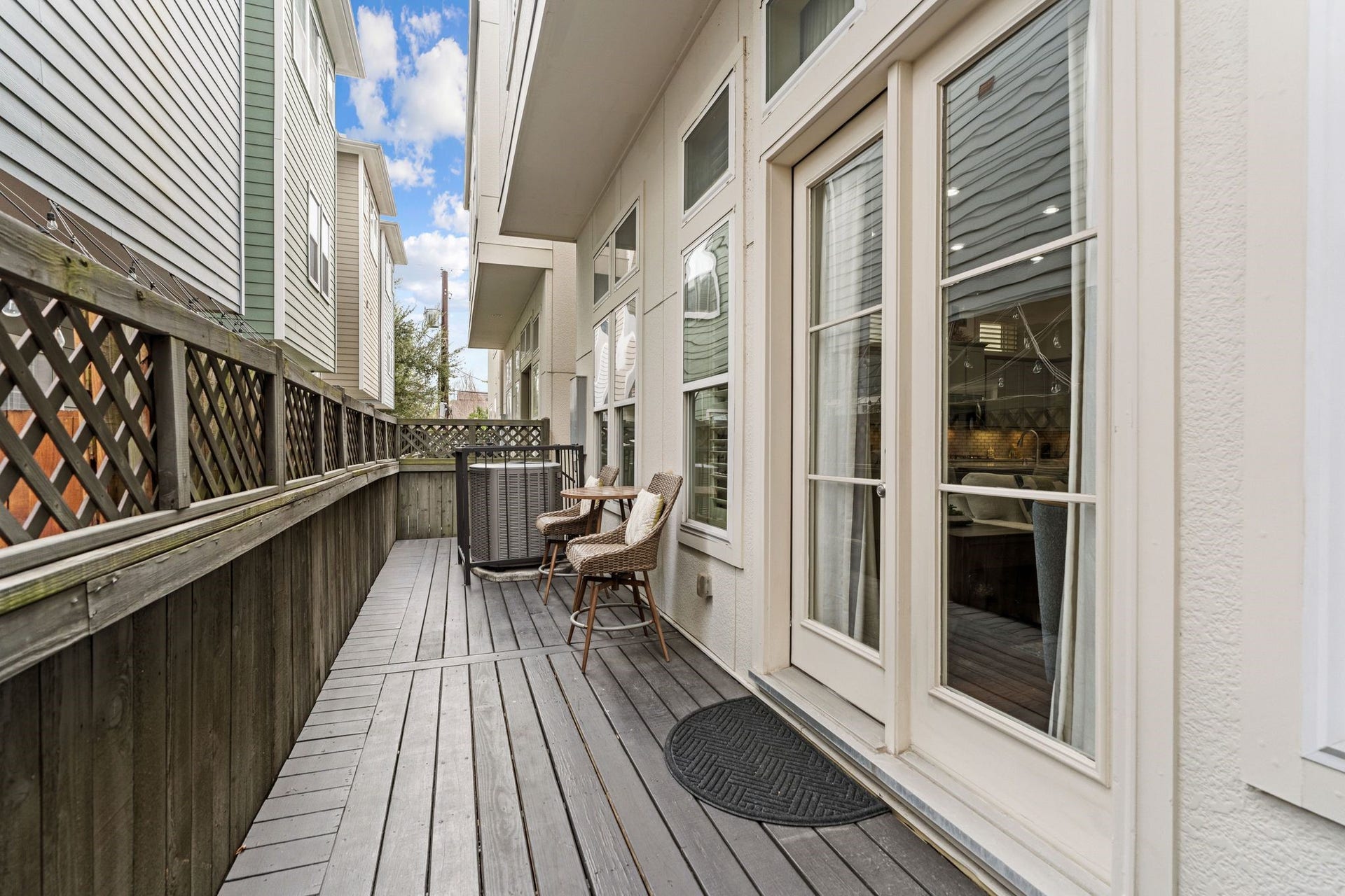 1337 W 24th Street, Houston, TX 77008 This reverse view shows the length of the deck, lattice-topped fencing and glass doors connecting the outdoor space with the home.