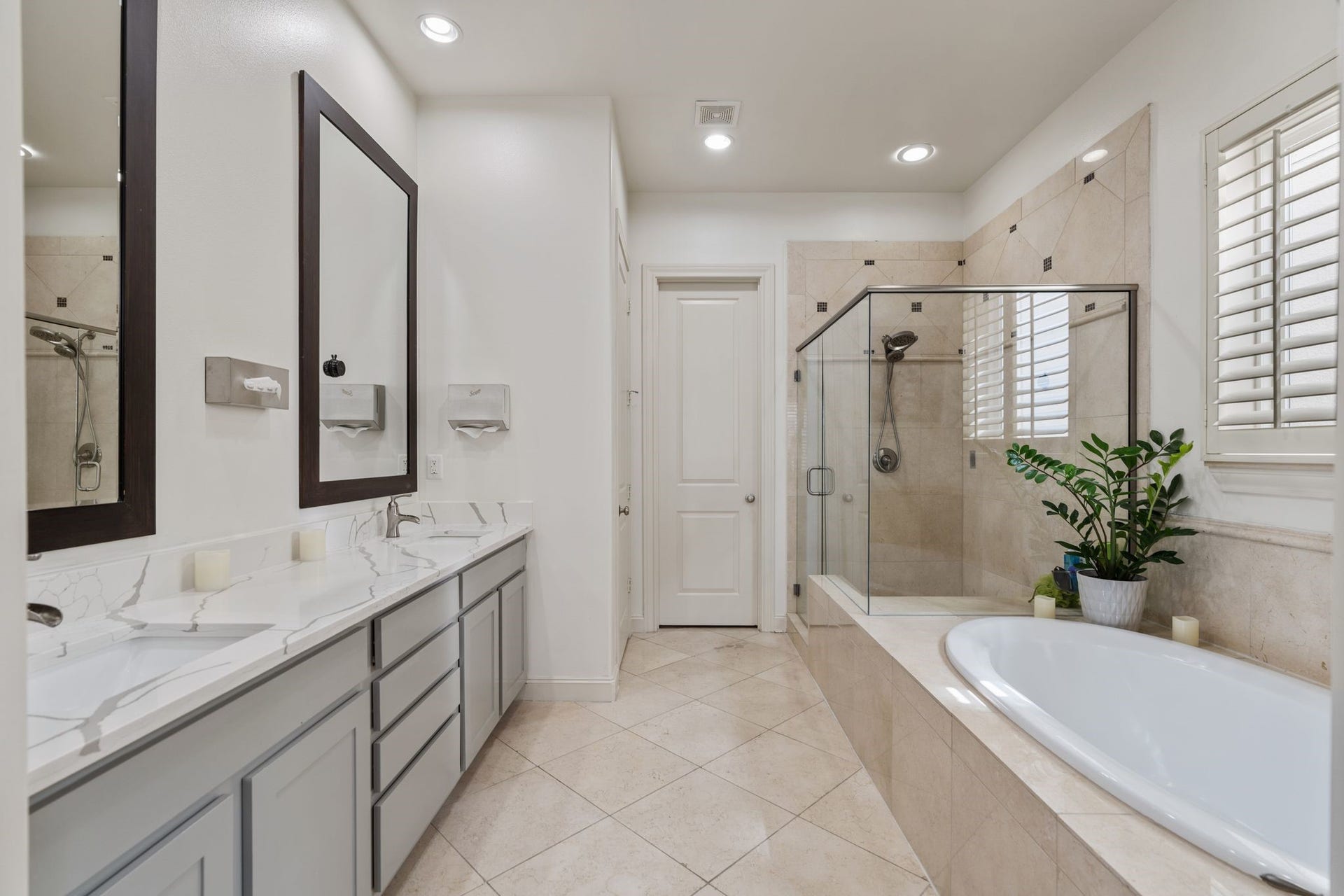 1337 W 24th Street, Houston, TX 77008 The ensuite spa primary bathroom has two sinks with an extended vanity with ample cabinetry, a soaking tub and a glass-enclosed shower, providing a well-appointed space to refresh and unwind.