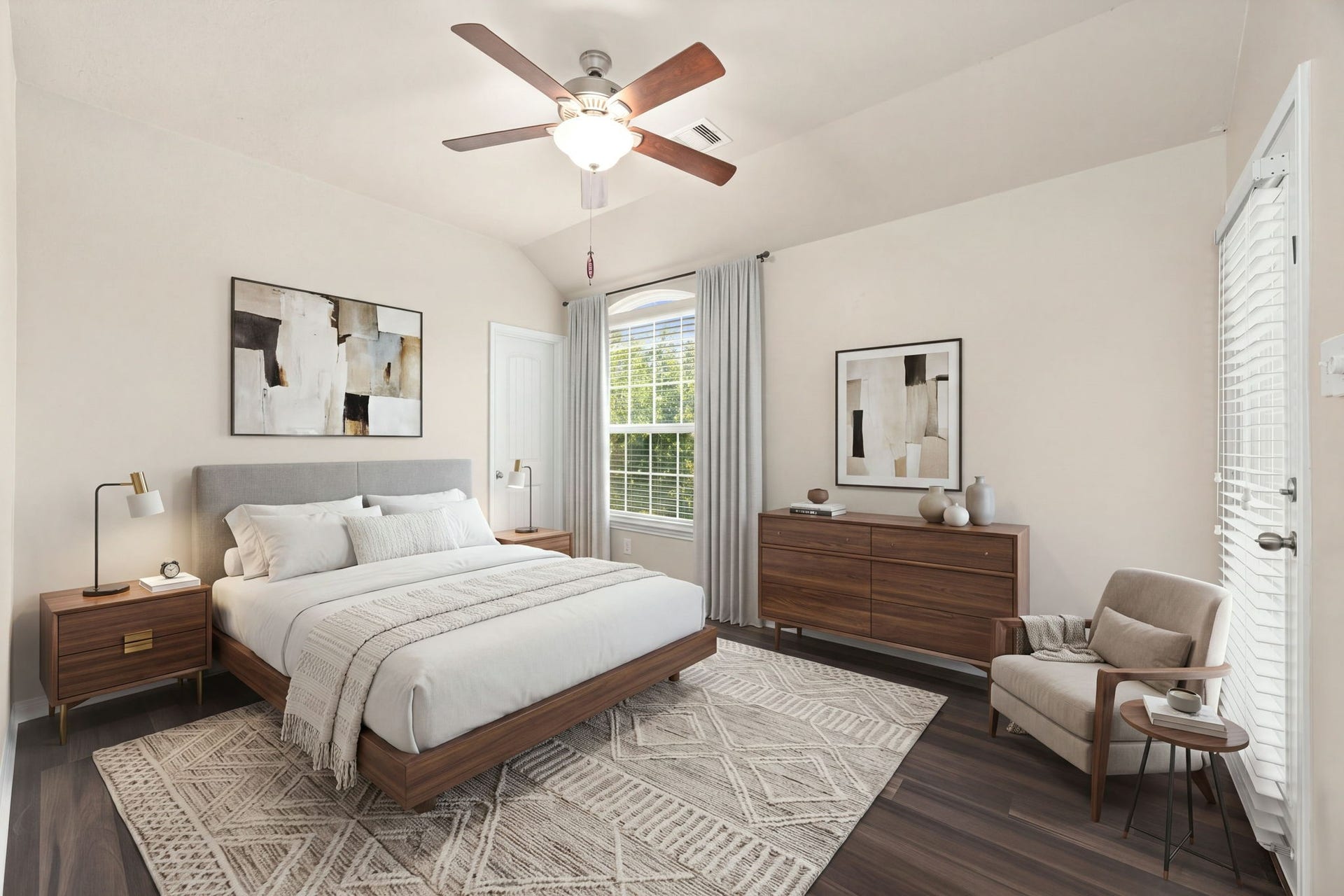 This exceptional secondary bedroom stands out with its own private outdoor access, opening directly onto a peaceful balcony through a full-lite glass door. The spacious room features soaring vaulted ceilings, a central arched window that frames views of the mature greenery, rich dark wood flooring, and a modern five-blade ceiling fan to complete the perfect guest retreat or junior suite. *Virtually Staged