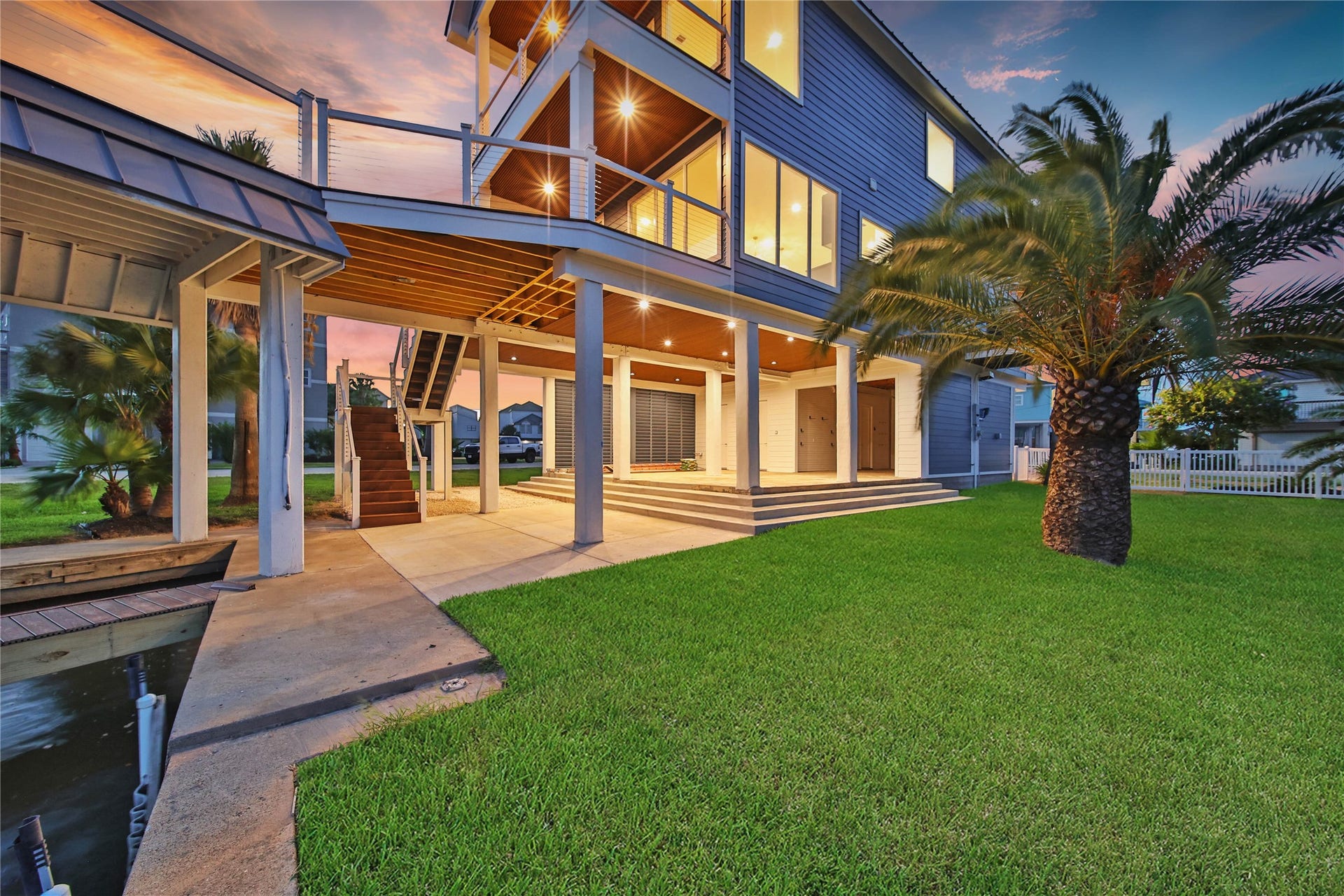 243 Bamaku Bend, Tiki Island, TX 77554 Rear view showcases the homes multiple outdoor living areas and expansive 12,000+ sqft waterfront lot.