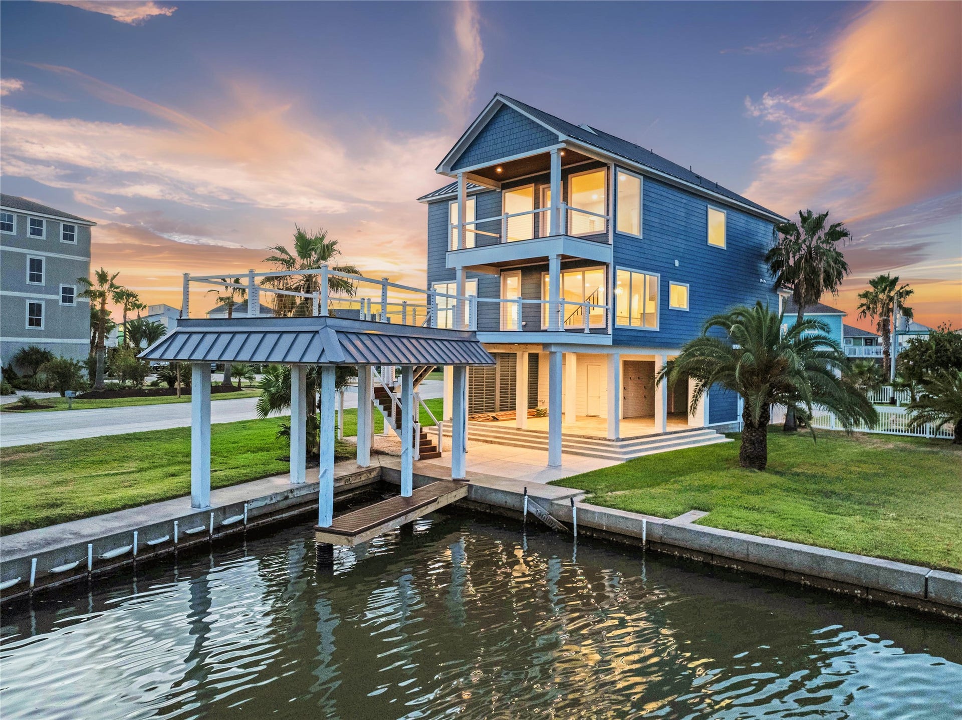 243 Bamaku Bend, Tiki Island, TX 77554 Beautiful waterfront living on Tiki Island. Private canal access, boat dock, sunset views showcasing multiple levels of outdoor living and picturesque coastal views.