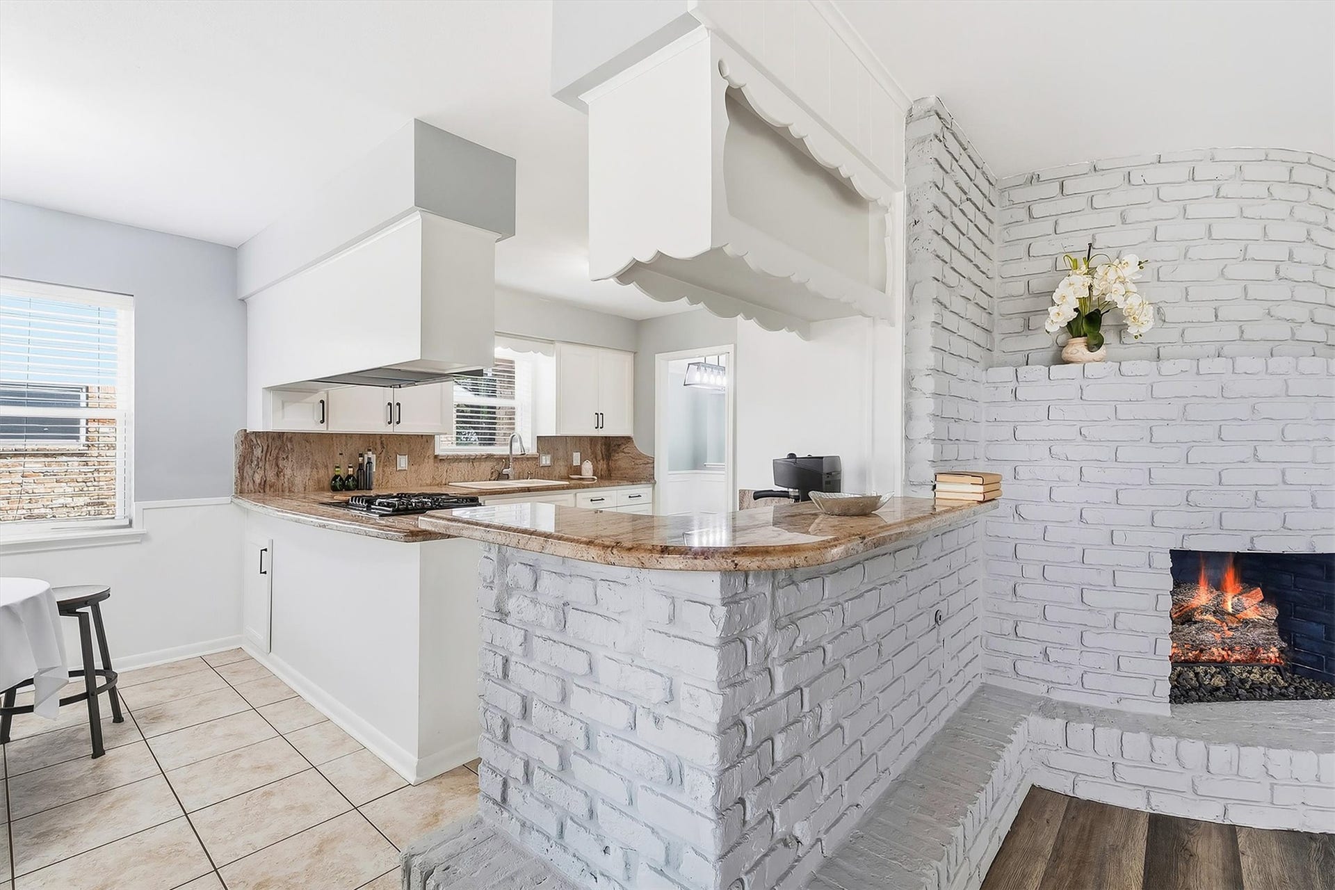 2503 Moss Hill Drive, Houston, TX 77080 Charming kitchen with a cozy brick fireplace, elegant countertops, and abundant natural light, perfect for warm gatherings.