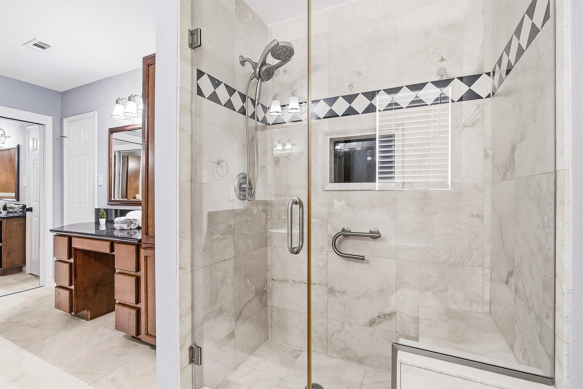 2503 Moss Hill Drive, Houston, TX 77080 Elegant bathroom featuring a spacious glass-enclosed shower with tile detailing and a sleek vanity area with ample storage.