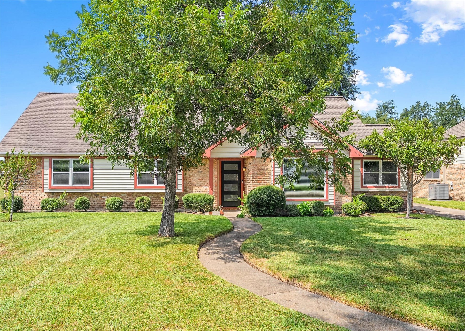 2503 Moss Hill Drive, Houston, TX 77080 Charming brick and siding home with a welcoming front path, mature trees, and well-maintained landscaping.