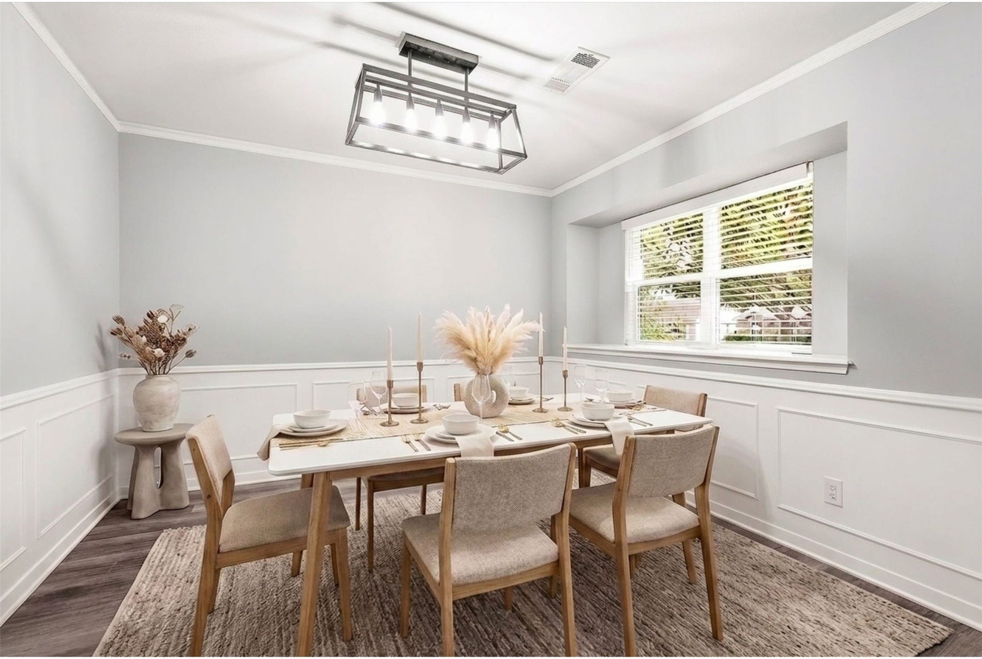 2503 Moss Hill Drive, Houston, TX 77080 Elegant dining room with soft gray walls, a modern chandelier, and a large window allowing natural light to fill the space. (Virtual Staging)
