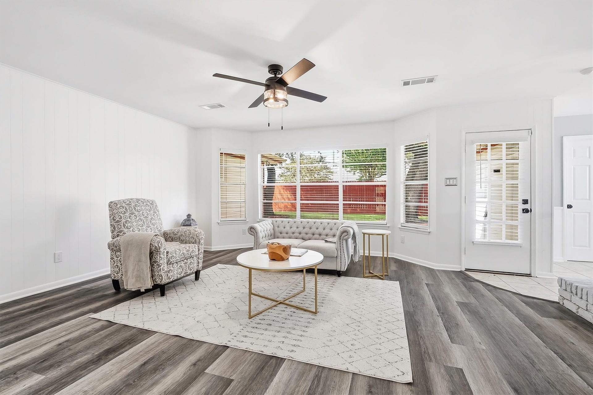 2503 Moss Hill Drive, Houston, TX 77080 Bright and inviting living area with large windows, stylish flooring, and a modern ceiling fan, perfect for relaxation and entertaining.