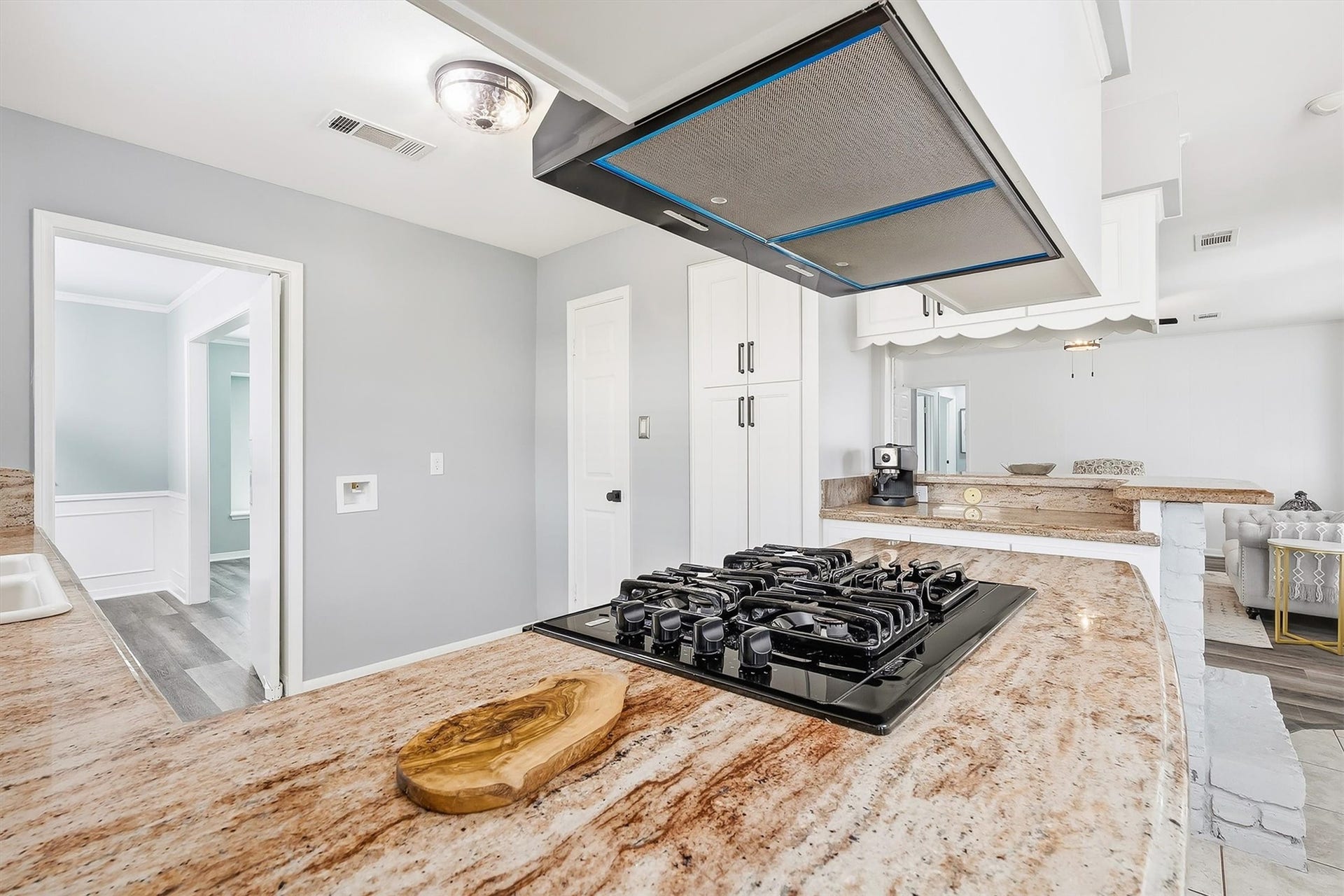 2503 Moss Hill Drive, Houston, TX 77080 Spacious kitchen with elegant granite countertops, a sleek gas cooktop, and ample cabinetry, flowing seamlessly into a cozy living area.