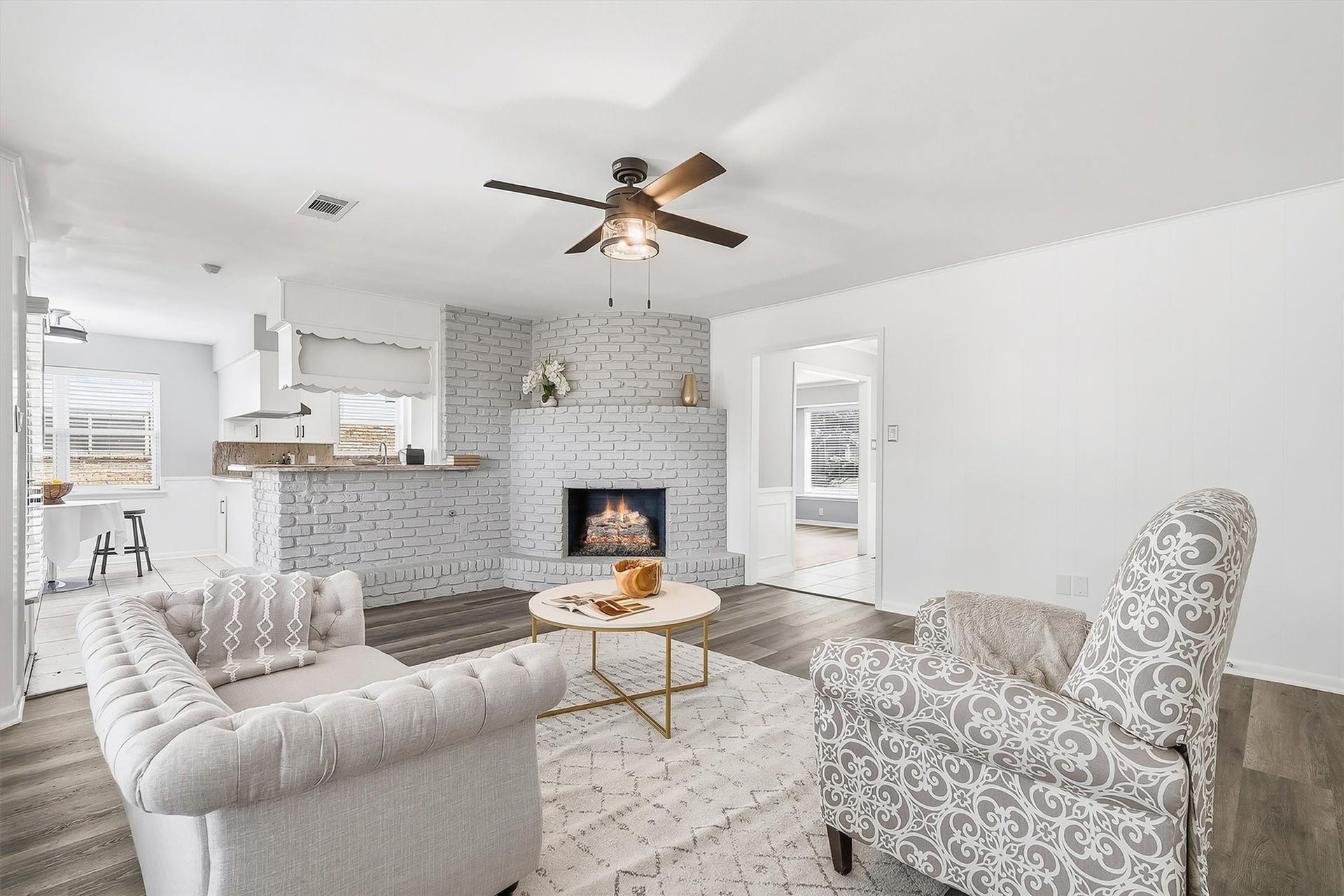 2503 Moss Hill Drive, Houston, TX 77080 Inviting living area featuring a cozy fireplace, elegant wood flooring, and an open layout that flows seamlessly into a modern kitchen.