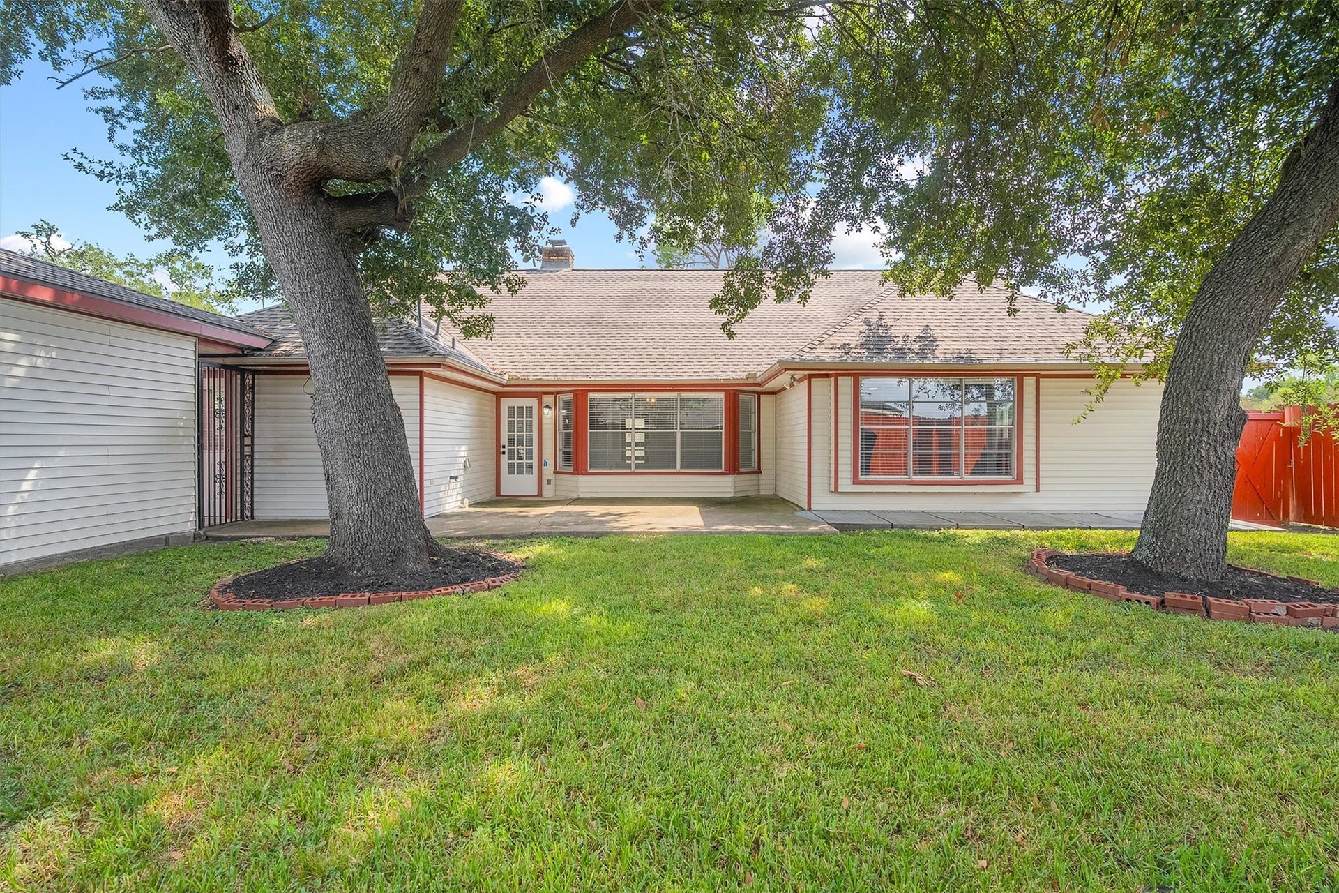 2503 Moss Hill Drive, Houston, TX 77080 Charming home with a spacious backyard, shaded by mature trees and featuring a cozy patio area for outdoor relaxation.