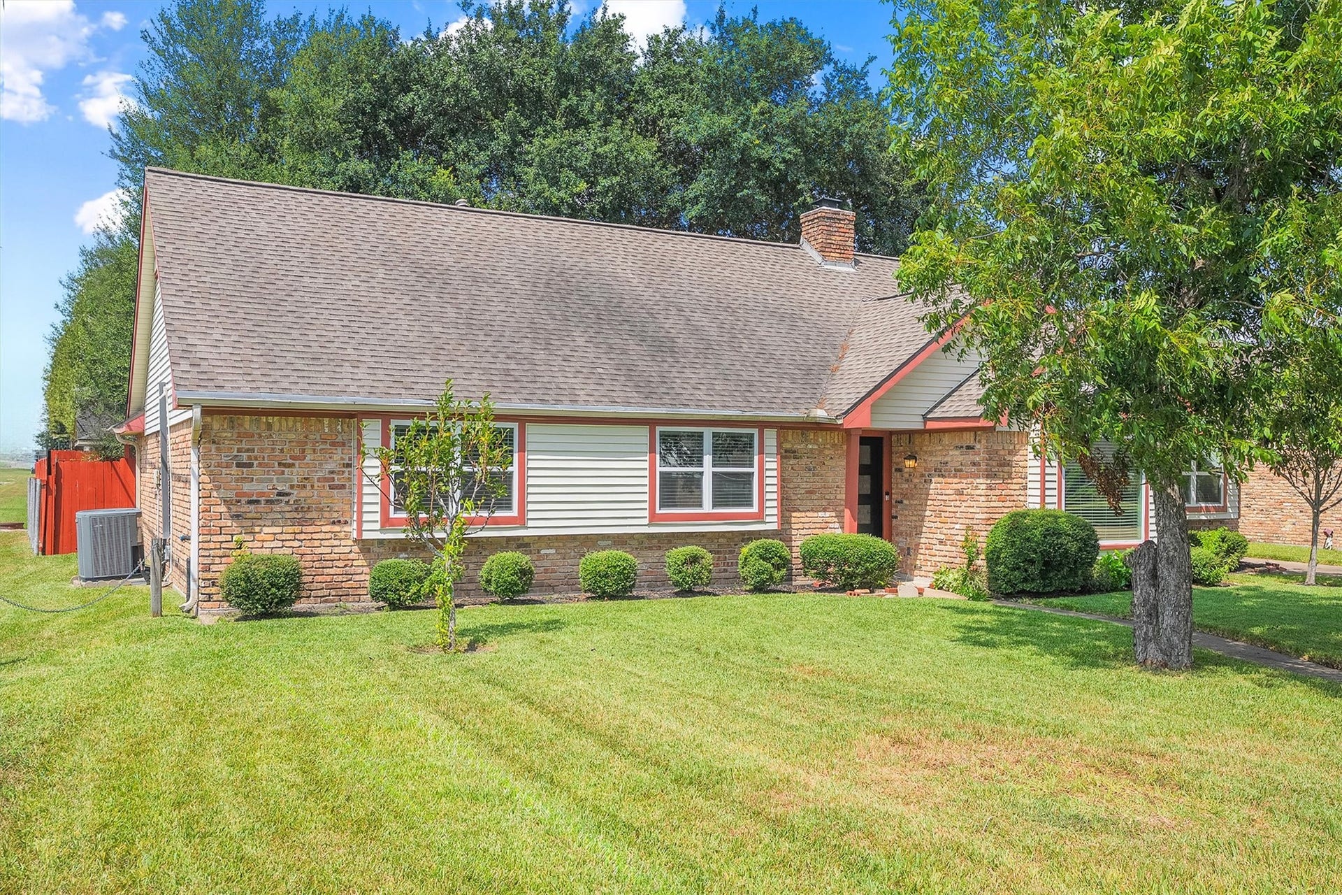 2503 Moss Hill Drive, Houston, TX 77080 Charming brick home with a welcoming front path, lush green lawn, and mature trees, offering great curb appeal in a serene setting.
