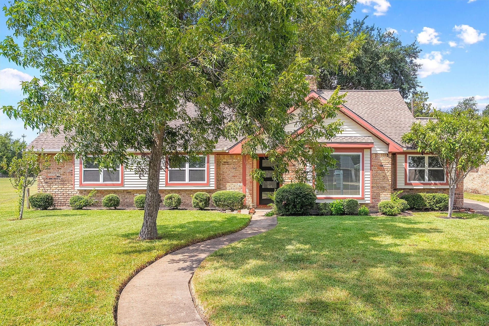 2503 Moss Hill Drive, Houston, TX 77080 Charming brick home with a welcoming front path, lush green lawn, and mature trees, offering great curb appeal in a serene setting.
