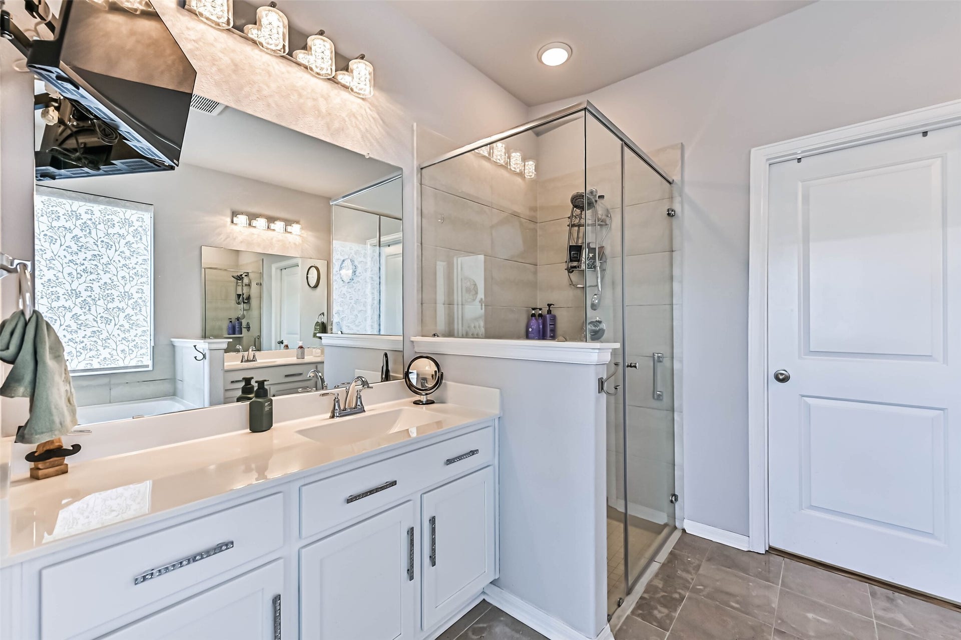 12527 Jetty Cove Drive, Texas City, TX 77568 Spacious primary bathroom featuring a long vanity, oversized mirror, modern lighting, and a separate glass-enclosed shower.