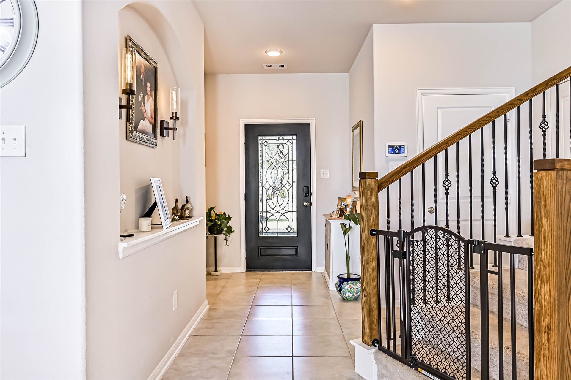 12527 Jetty Cove Drive, Texas City, TX 77568 Elegant front entry showcasing a decorative glass front door, tile flooring, architectural accents, and beautiful staircase details.