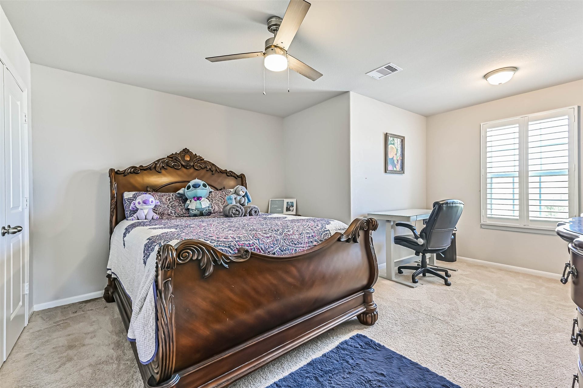 12527 Jetty Cove Drive, Texas City, TX 77568 Generously sized secondary bedroom with ceiling fan, plantation shutters, and space for a desk or study area.