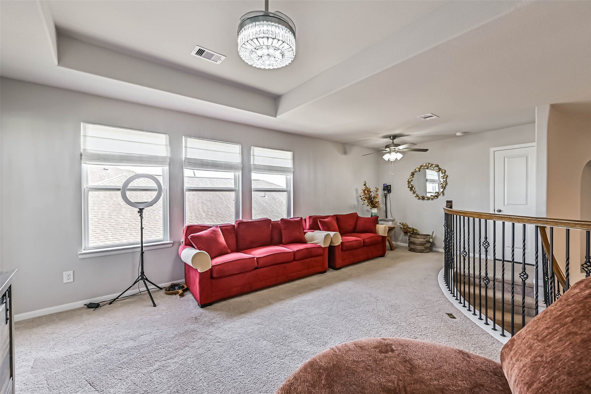 12527 Jetty Cove Drive, Texas City, TX 77568 Bright and inviting second-floor living space with multiple windows, decorative ceiling details, and beautiful wrought-iron railing.