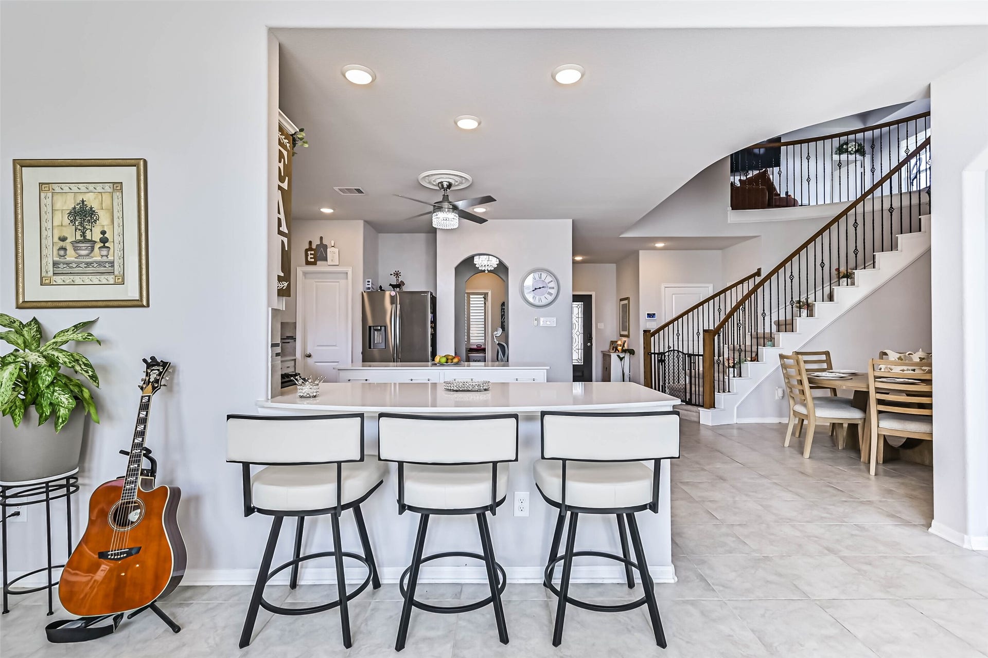 12527 Jetty Cove Drive, Texas City, TX 77568 Open-concept design seamlessly connects the kitchen, dining area, and elegant curved staircase, creating an inviting atmosphere.