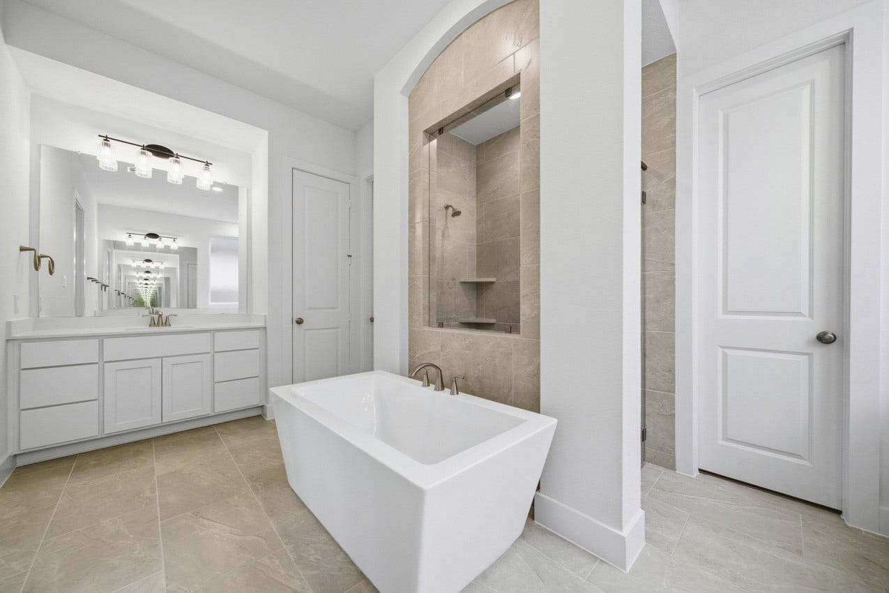 1535 Watermont Drive, Missouri City, TX 77459 Bright and spacious primary bathroom designed with modern finishes and a relaxing soaking tub.