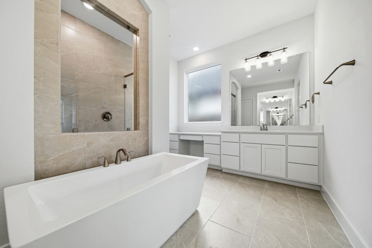 1535 Watermont Drive, Missouri City, TX 77459 Spa-inspired primary bath with dual vanities, a freestanding tub, and a walk-in shower.