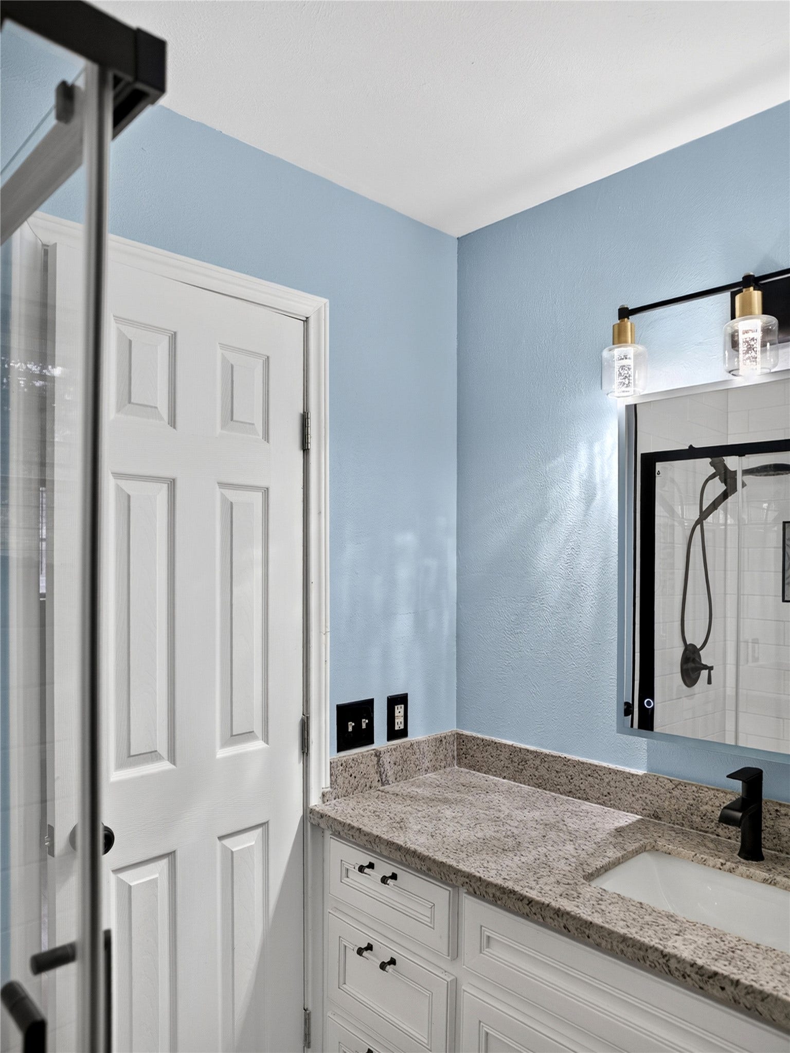 2408 Blueberry Lane, Pasadena, TX 77502 Primary bathroom with granite countertop, white vanity, and modern black fixtures.