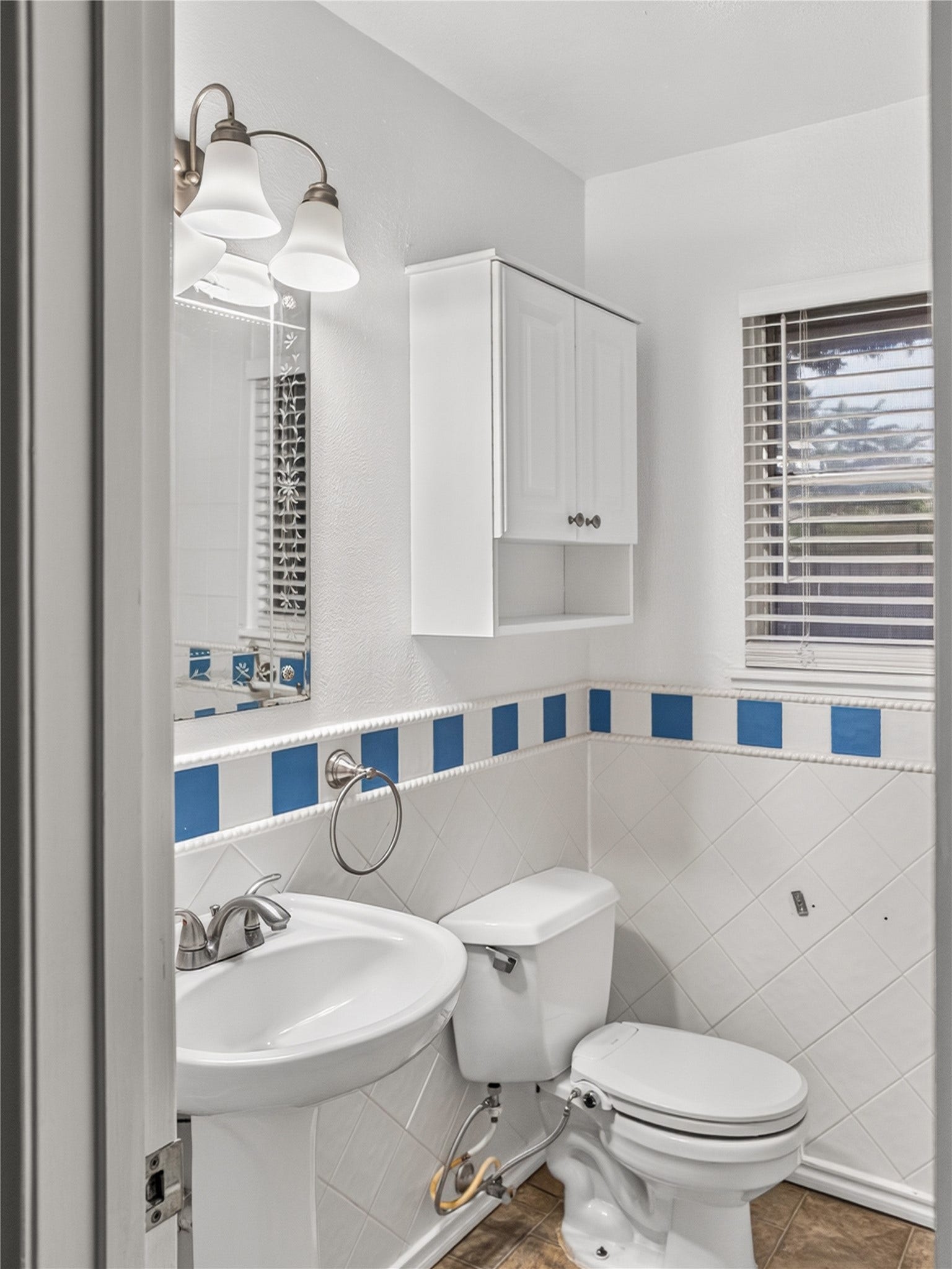 2408 Blueberry Lane, Pasadena, TX 77502 Guest bathroom featuring pedestal sink, decorative tile, and storage cabinet.
