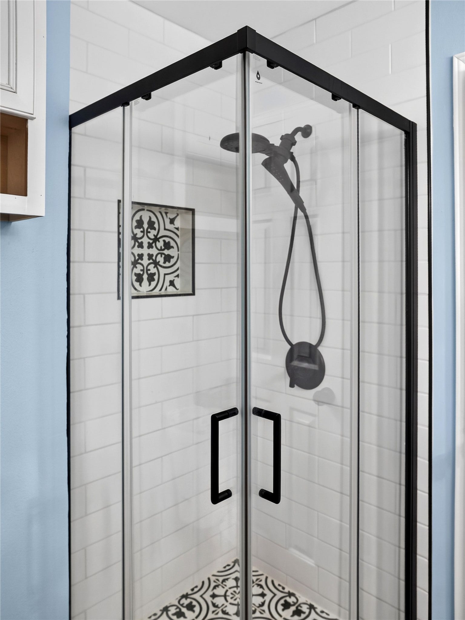 2408 Blueberry Lane, Pasadena, TX 77502 Primary bathroom featuring glass-enclosed shower with black fixtures and decorative tile accents.