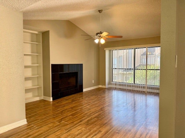 6701 Sands Point Drive, #26, Houston, TX 77074 Living room with built-in bookshelves and wood-burning fireplace.