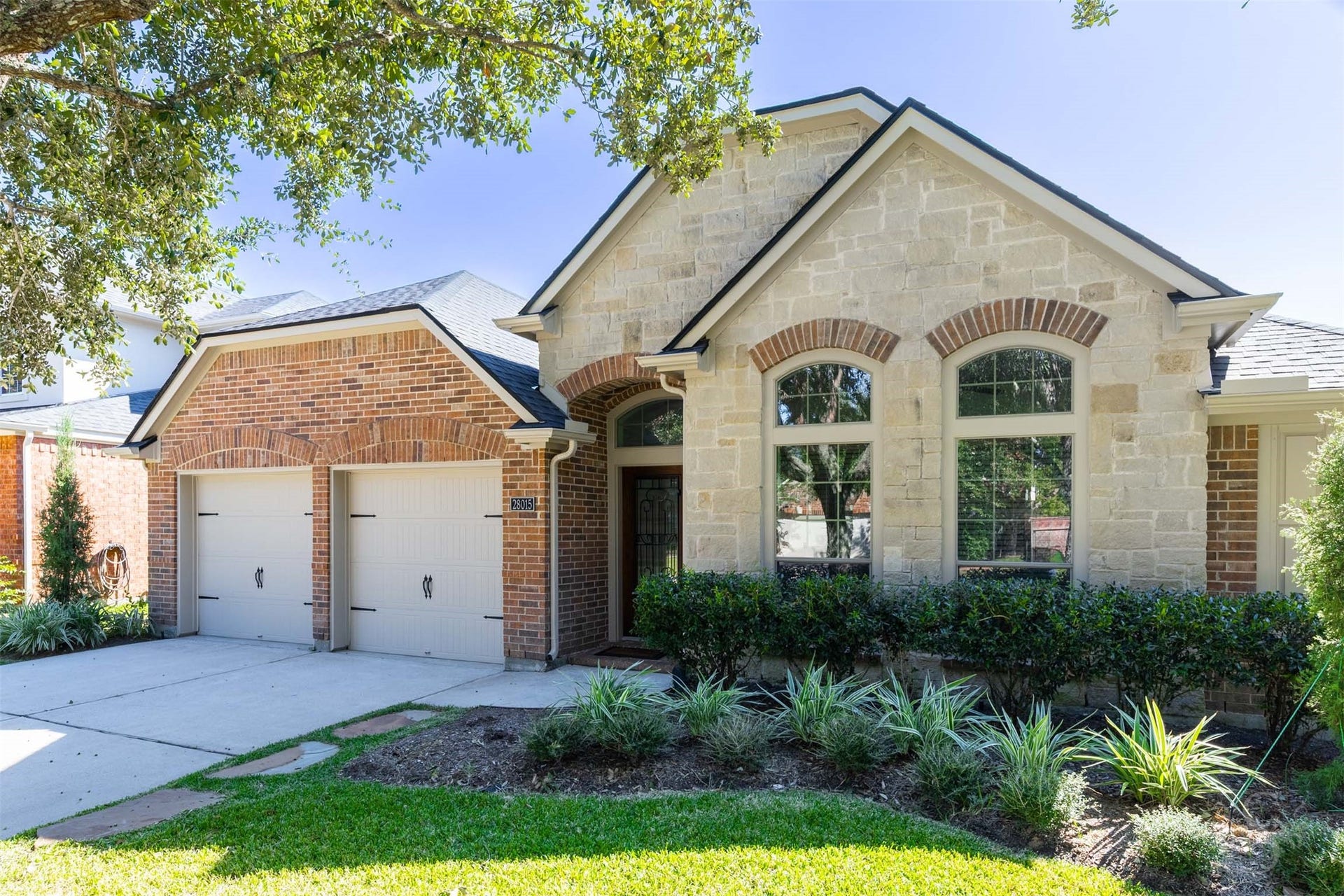 28015 Barberry Banks Lane, Fulshear, TX 77441 Beautiful brick and stonework, arched windows and layered gables give this home exceptional curb appeal. Mature trees and lush landscaping frame the welcoming covered entry.