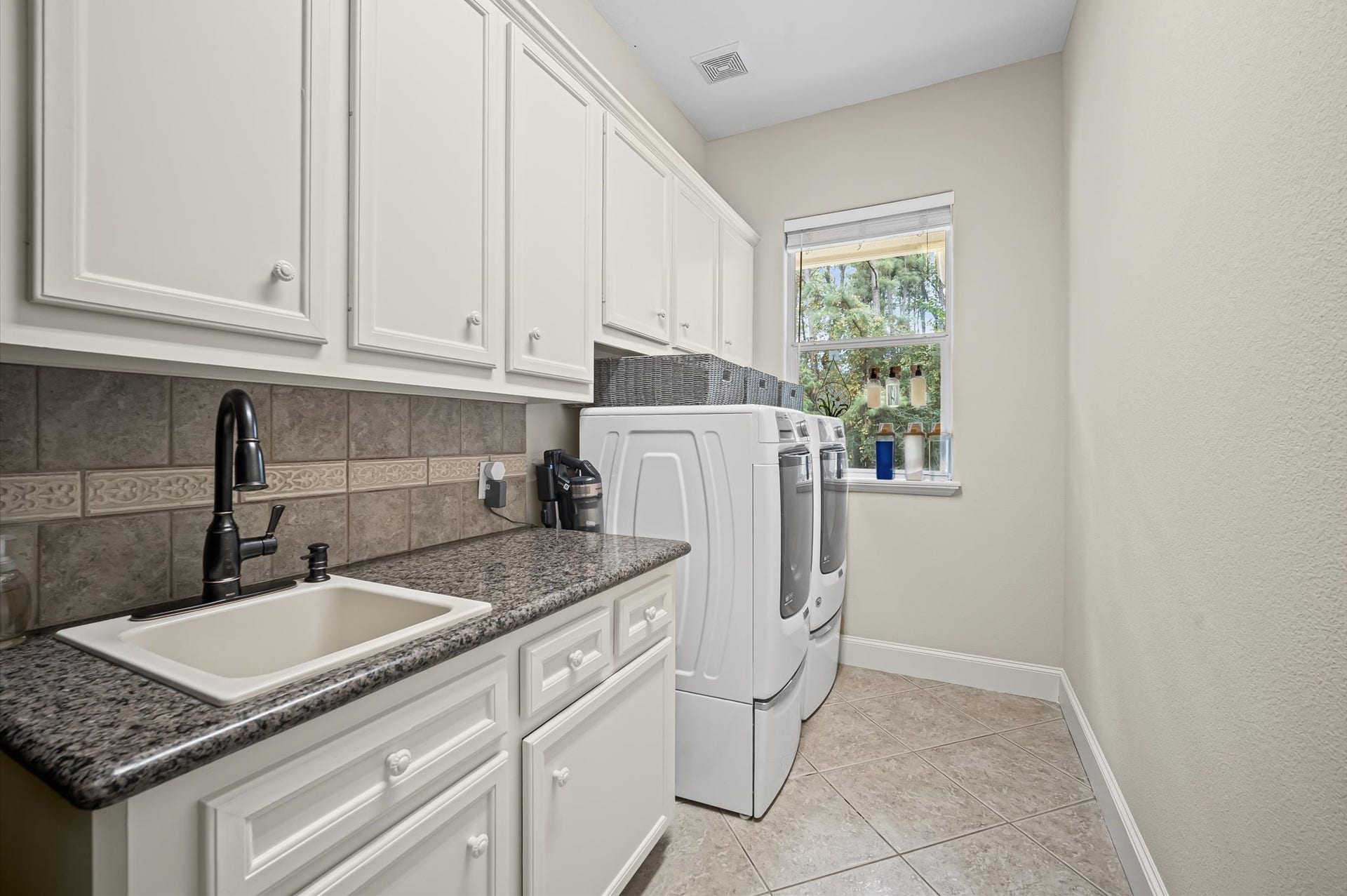 25815 Bridle Creek Drive S, Magnolia, TX 77355 Spacious laundry room with abundant cabinetry, folding counter and natural light