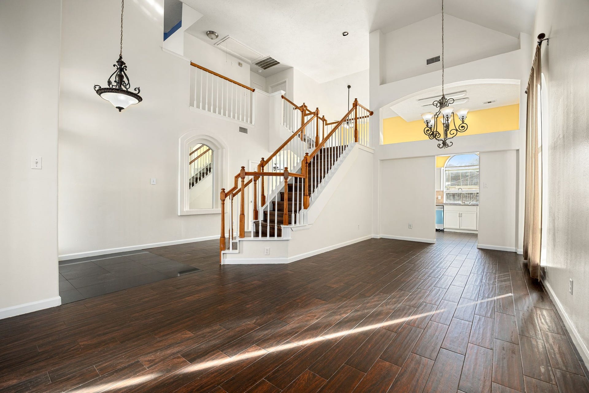 6306 Pago Lane, Houston, TX 77041 This versatile space flows seamlessly into the dining area, with a striking staircase and chandelier adding architectural charm throughout.