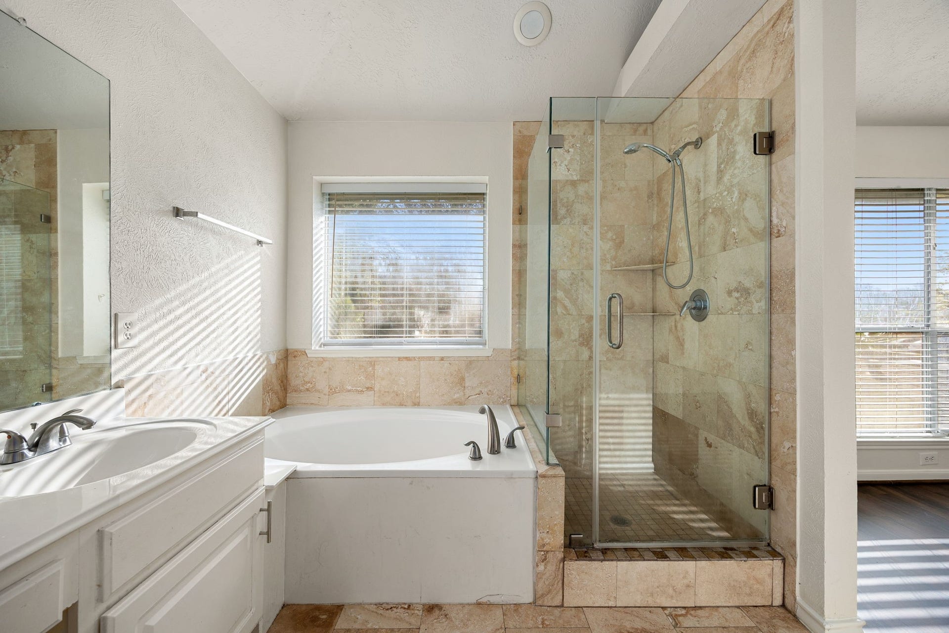 6306 Pago Lane, Houston, TX 77041 A relaxing corner soaking tub pairs beautifully with the separate glass-enclosed shower, creating a true spa-like retreat within the ensuite bath.