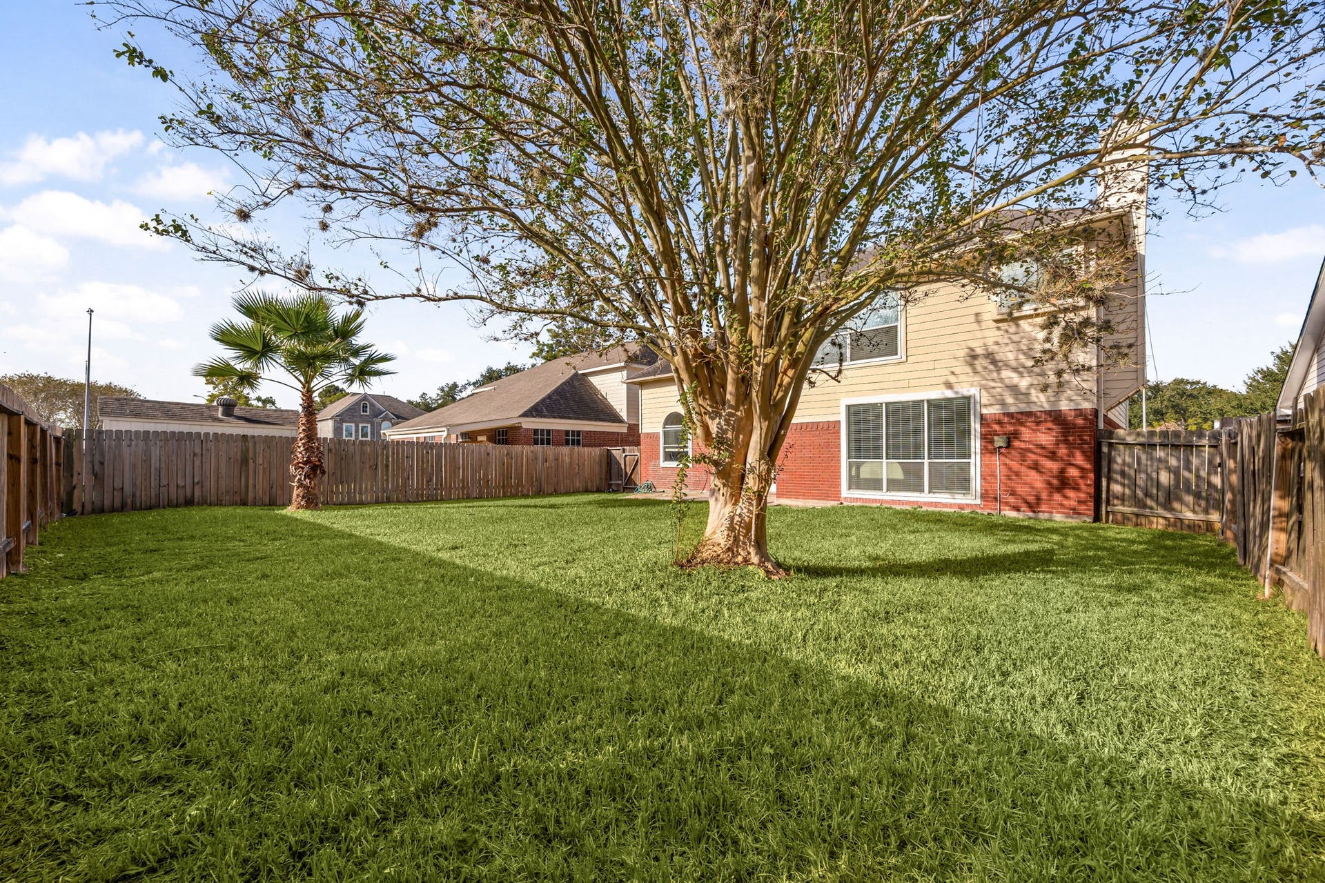 6306 Pago Lane, Houston, TX 77041 The expansive backyard offers a lush lawn and mature trees, creating a private outdoor retreat.