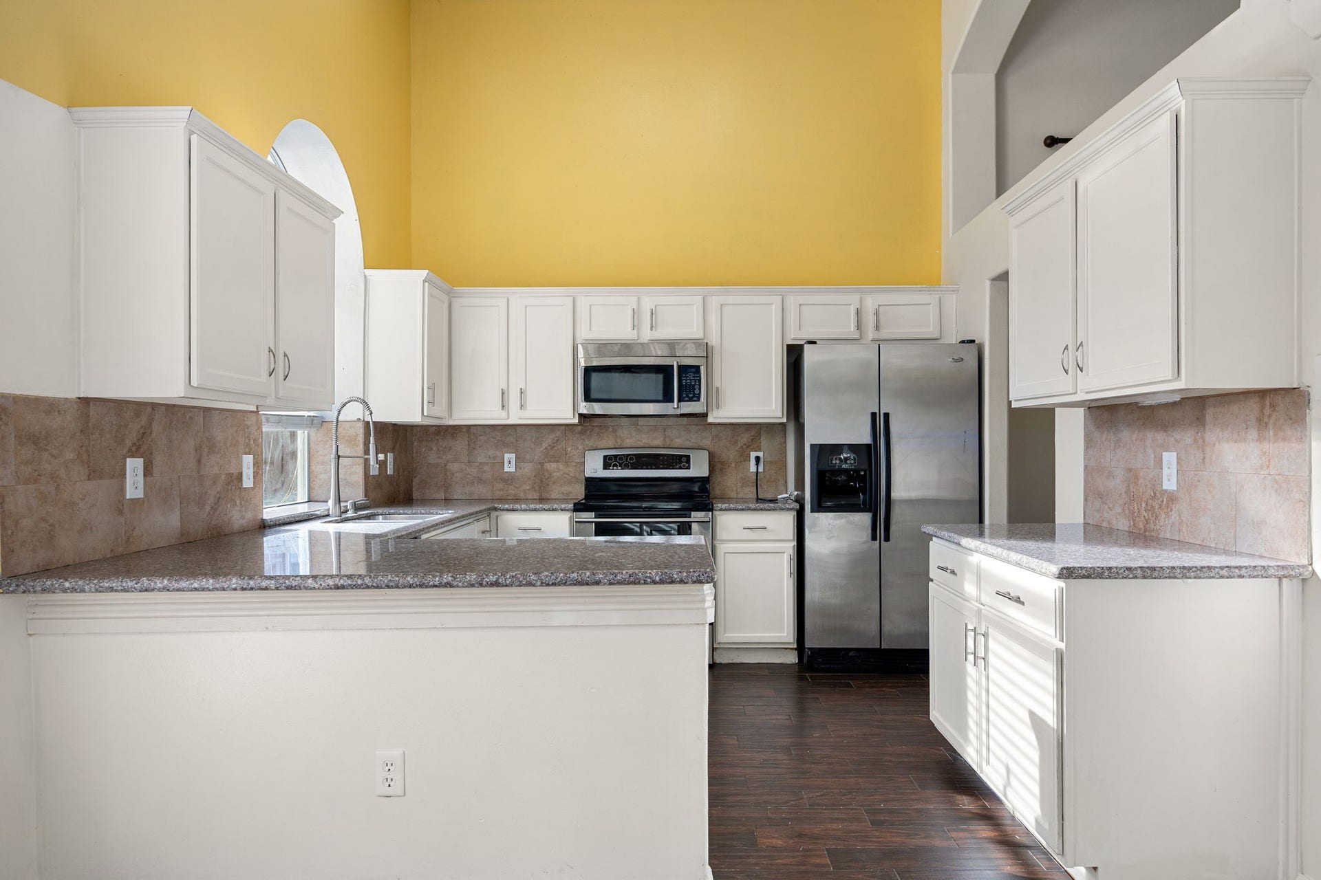 6306 Pago Lane, Houston, TX 77041 Crisp white cabinetry and breakfast bar seating complete this well-equipped kitchen, perfect for quick meals or casual entertaining.