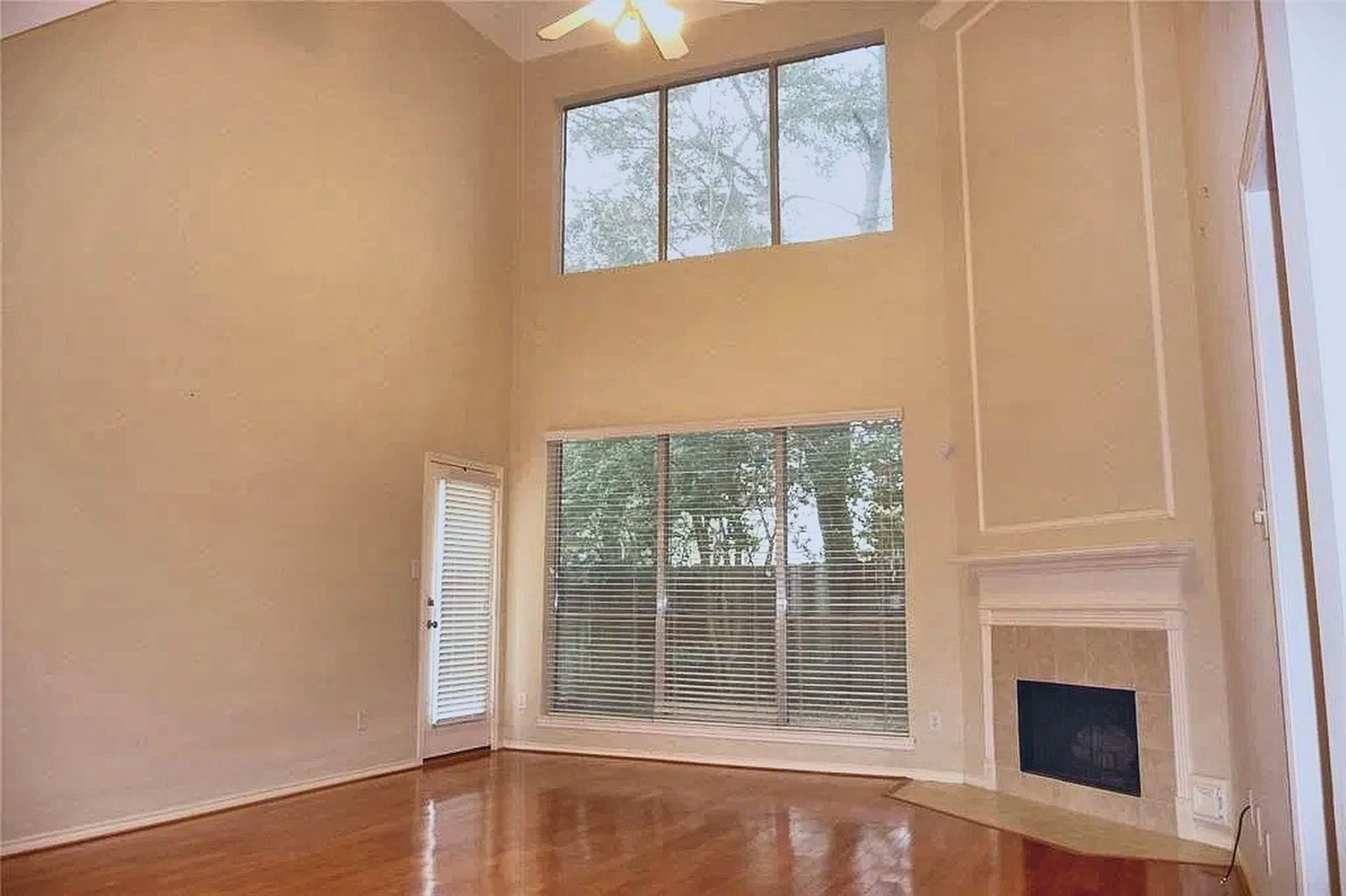 4023 Creek Ridge Lane, Missouri City, TX 77459 Soaring two-story living room with gas-log fireplace and gleaming hardwood floors.