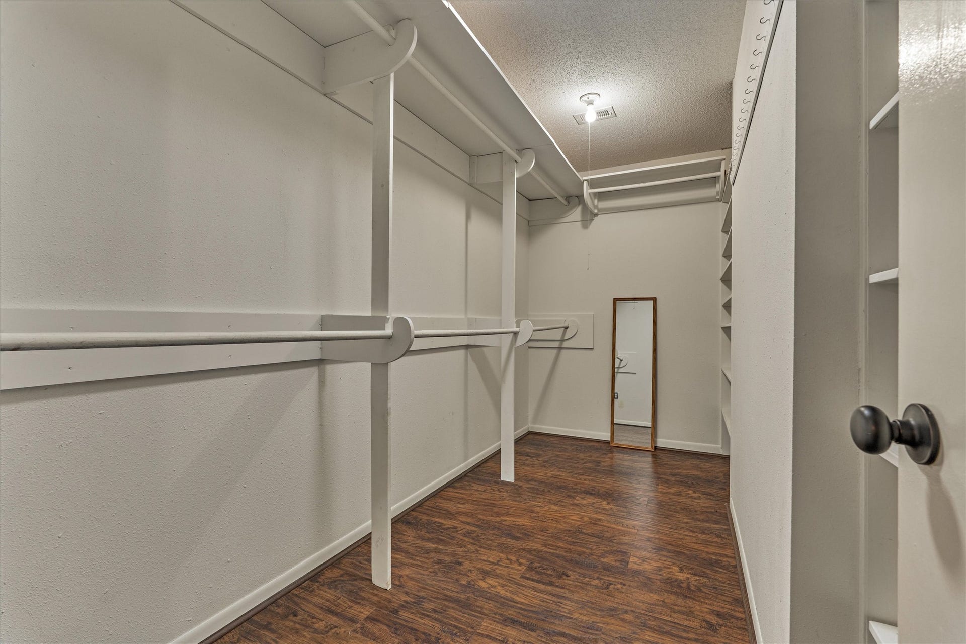 402 Shadywood Circle, Conroe, TX 77304 Spacious walk-in closet featuring built-in shelving and multiple hanging racks, offering plenty of storage and organization options to fit your needs.