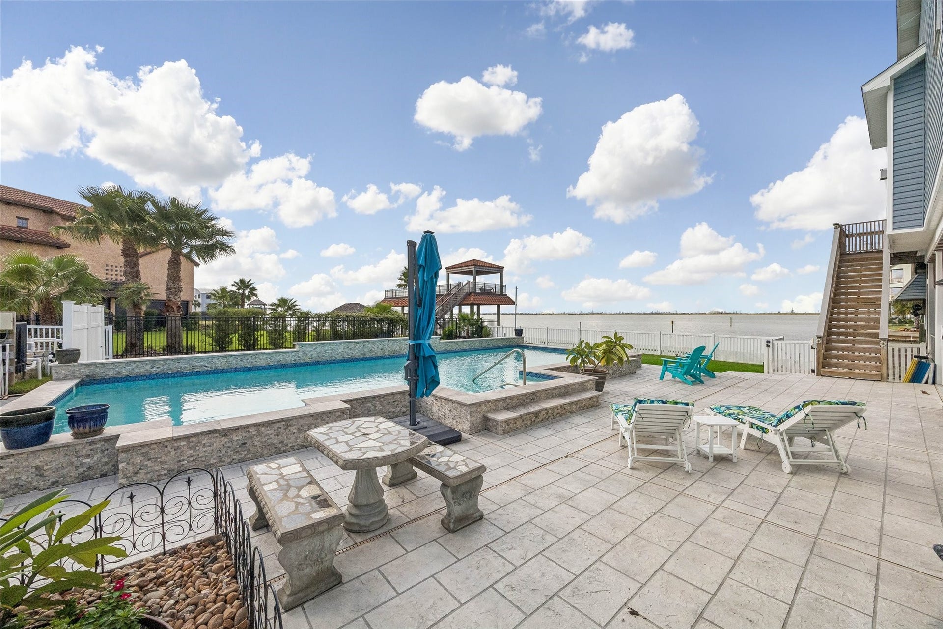 426 Sunset Circle, Tiki Island, TX 77554 Impressive pool design and the surrounding outdoor space, with generous room for lounge seating, sunbathing, gatherings, and relaxing poolside.