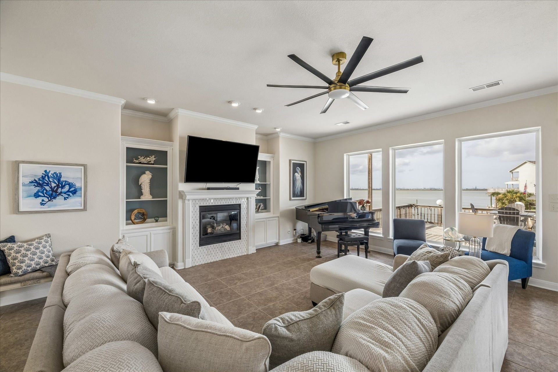 426 Sunset Circle, Tiki Island, TX 77554 Spacious living area featuring a full wall of windows overlooking the Bay, filling the room with natural light and showcasing stunning waterfront views.