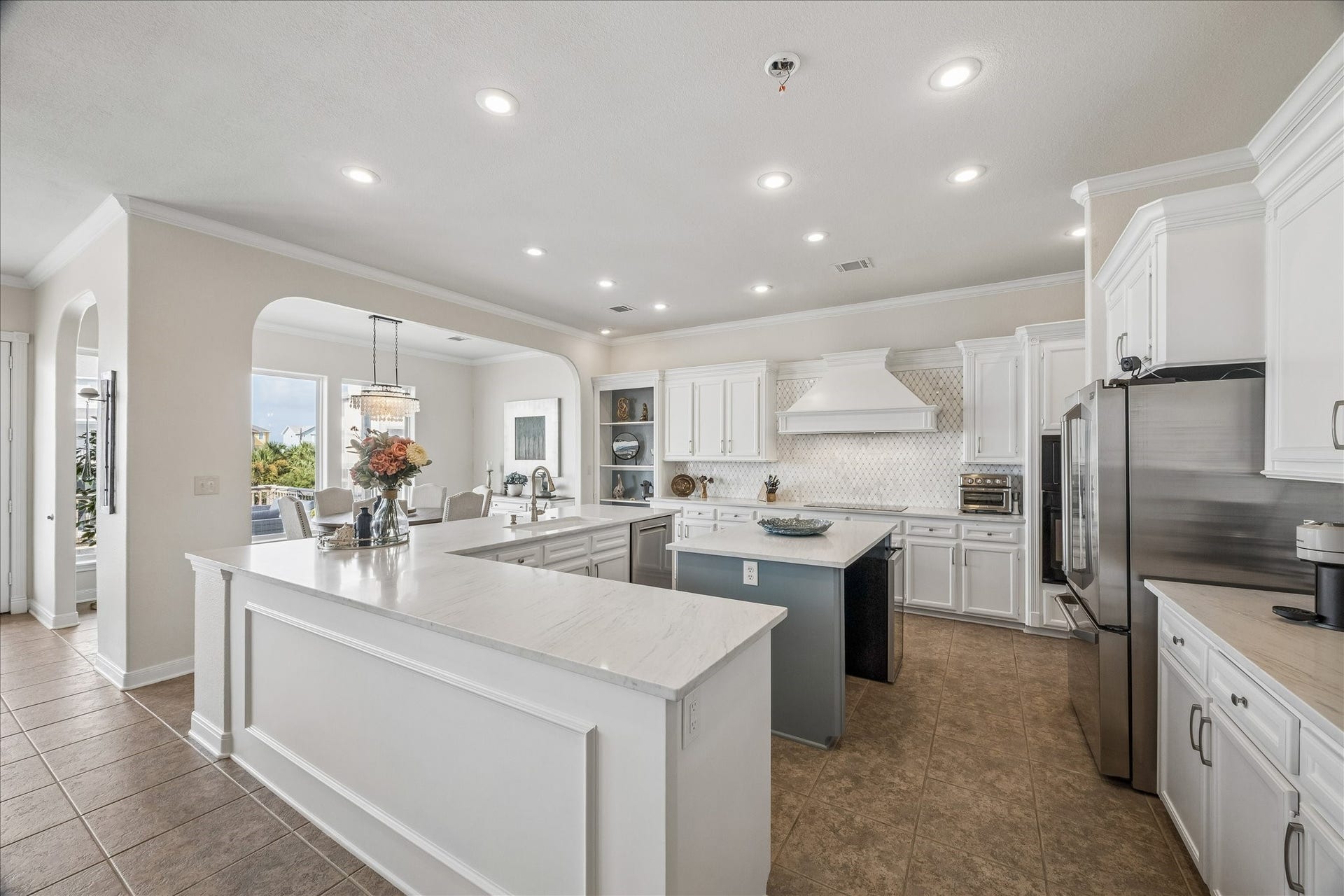 426 Sunset Circle, Tiki Island, TX 77554 Kitchen showcases new quartz countertops, a spacious island with storage and breakfast bar seating, plus two sinksa full-size sink and a separate prep sink for added functionality.