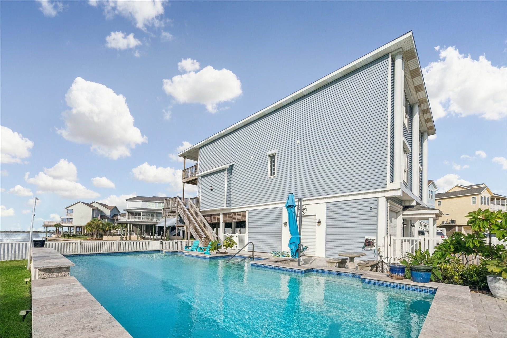 426 Sunset Circle, Tiki Island, TX 77554 MASSIVE pool includes a beautiful waterfall feature (See video link) creating a relaxing backyard retreat perfect for enjoying the coastal setting. 10X10 ft Cantilever Patio umbrella, base & solar lights.