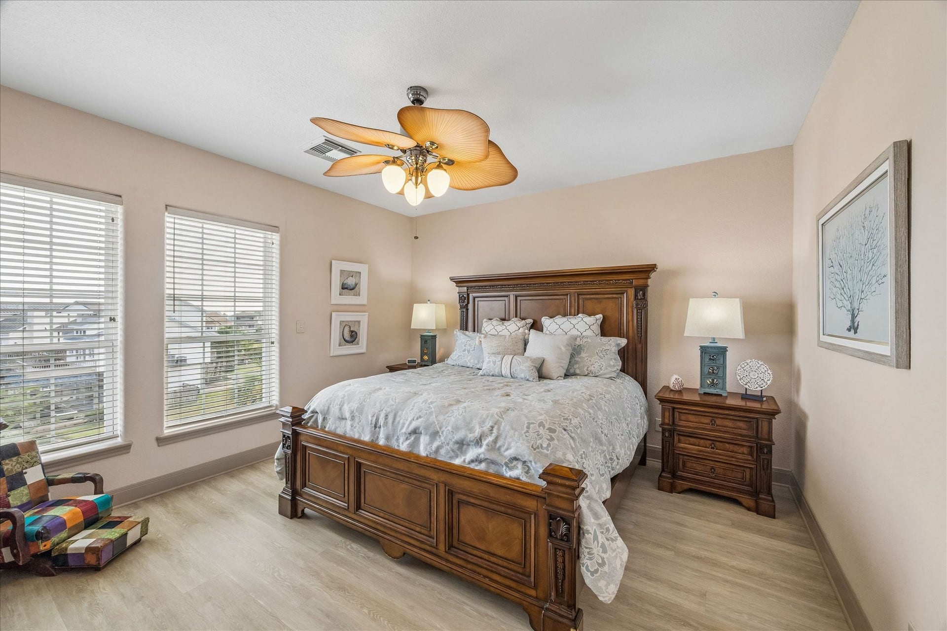 426 Sunset Circle, Tiki Island, TX 77554 3rd level guest bedroom with laminate wood flooring, a walk-in closet, and convenient access to a full guest bathroom. Front-facing windows provide natural light and views overlooking the front of the home.